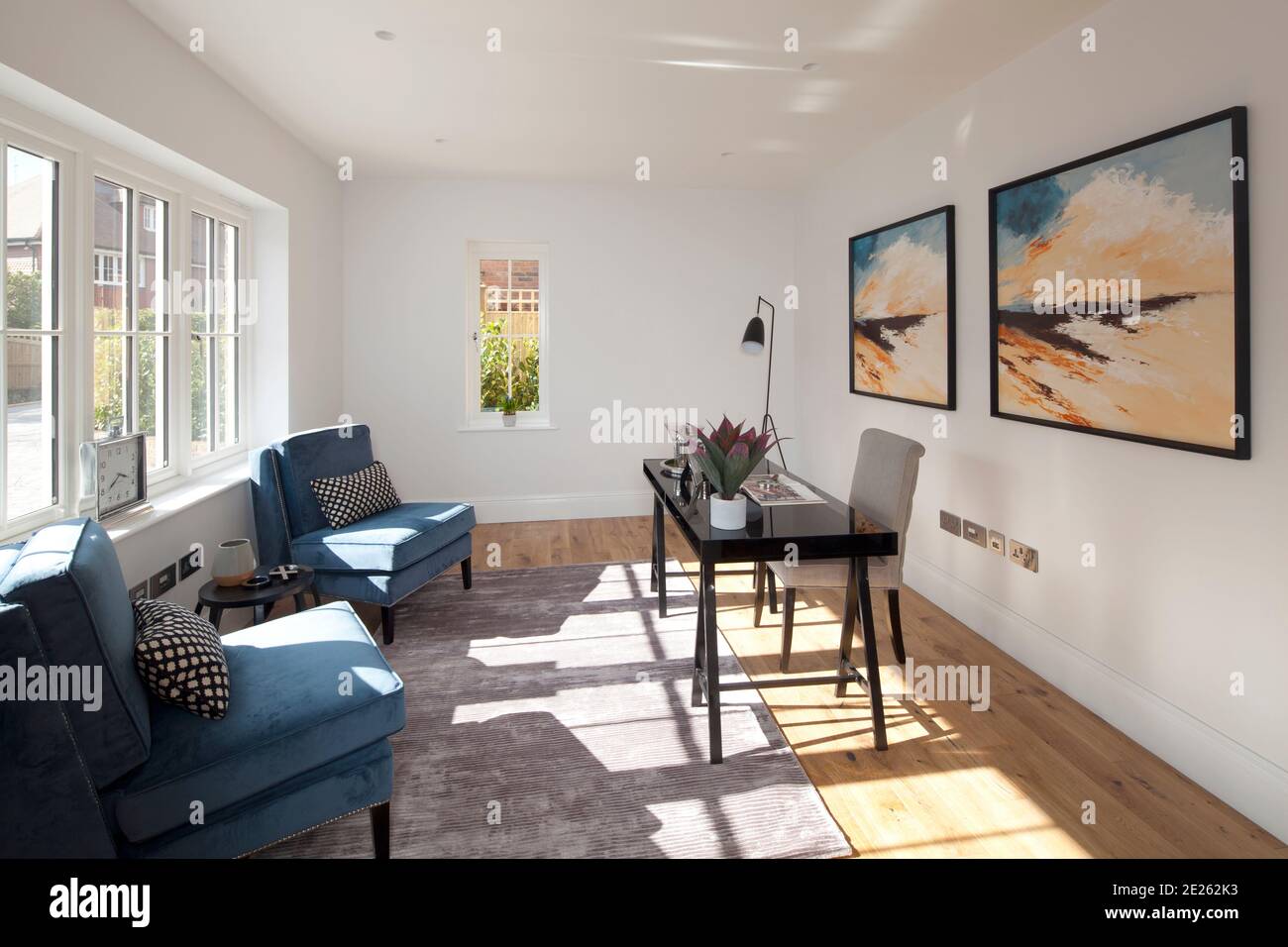 Studio moderno e soleggiato con dipinti sulla parete per la casa ufficio Foto Stock