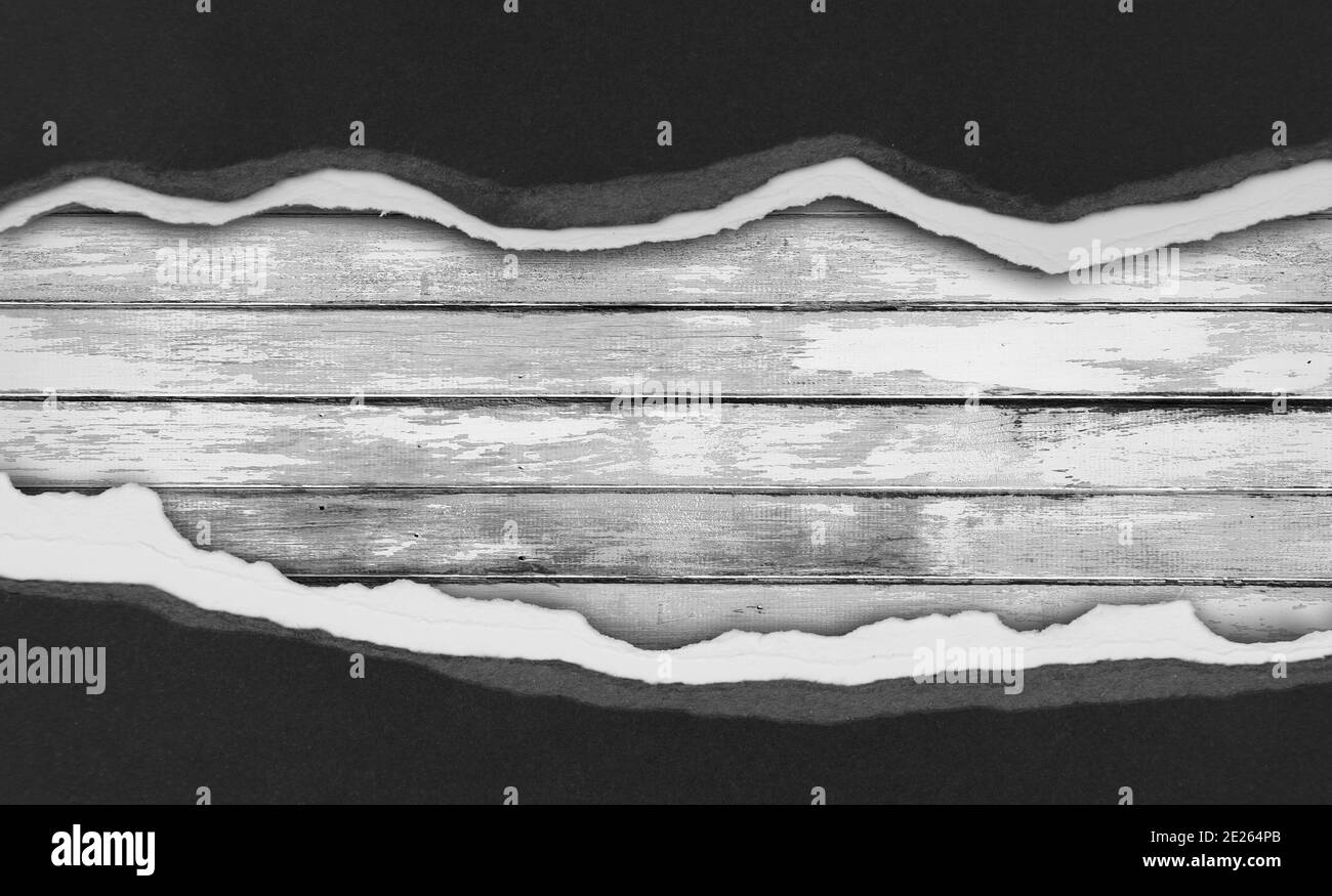 Carta nera strappata su tavole di legno Foto Stock