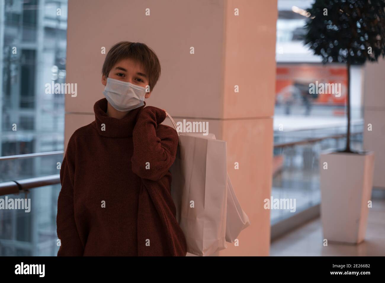 tenendo mano shopping borse persona indossare maschera. centro commerciale 2021 nuovo anno e shopping di natale, regalo. contro l'uso di plastica. Foto Stock