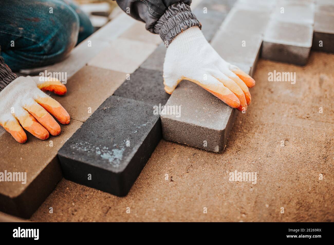 Incollaggio di piastrelle di granito a pavimenti in cemento al di fuori della casa - portico e patio rivestito Foto Stock