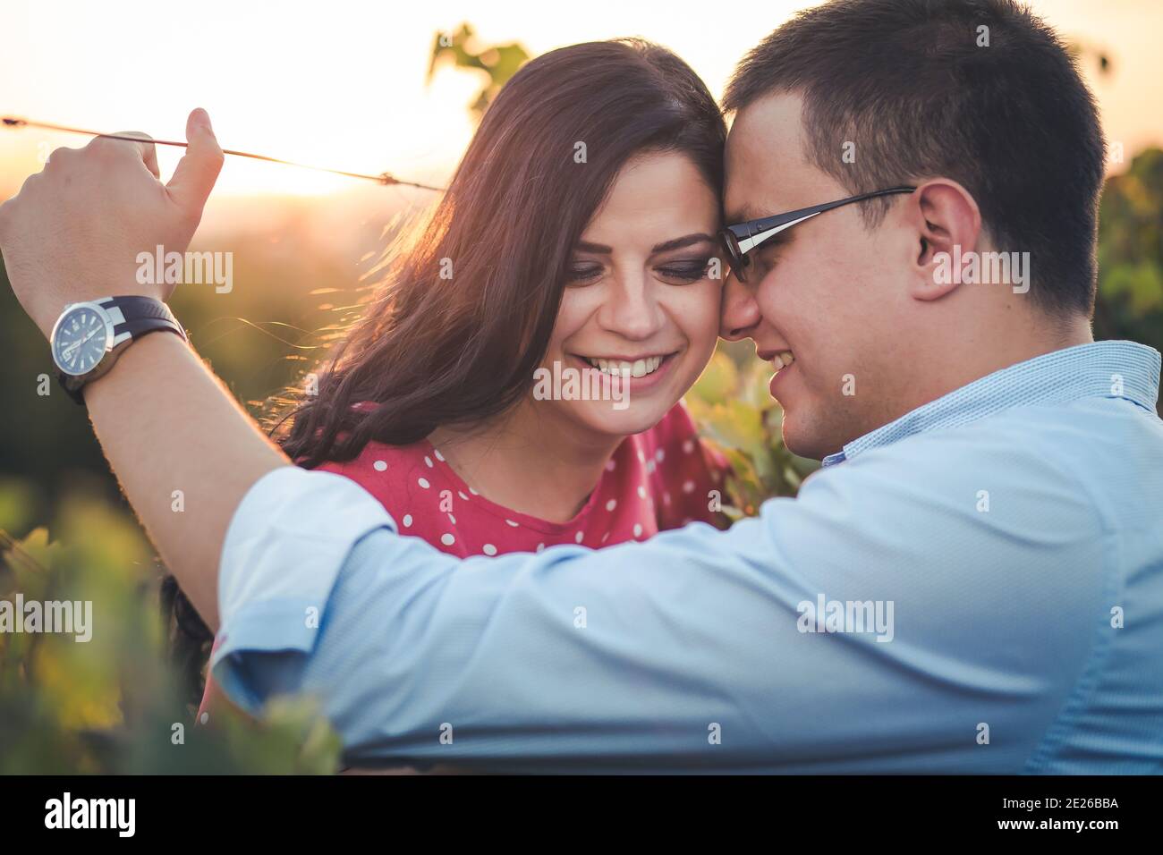 Ritratto esterno di una giovane coppia sorridente. Romanticismo, gesti romantici. Luce pomeridiana Foto Stock