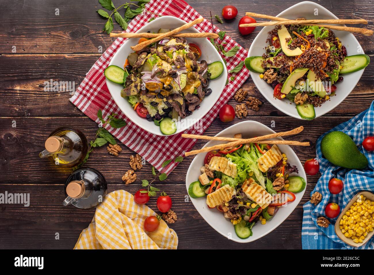 3 tipi di insalata con quinoa, halloumi e bistecca su tavolo di legno Foto Stock