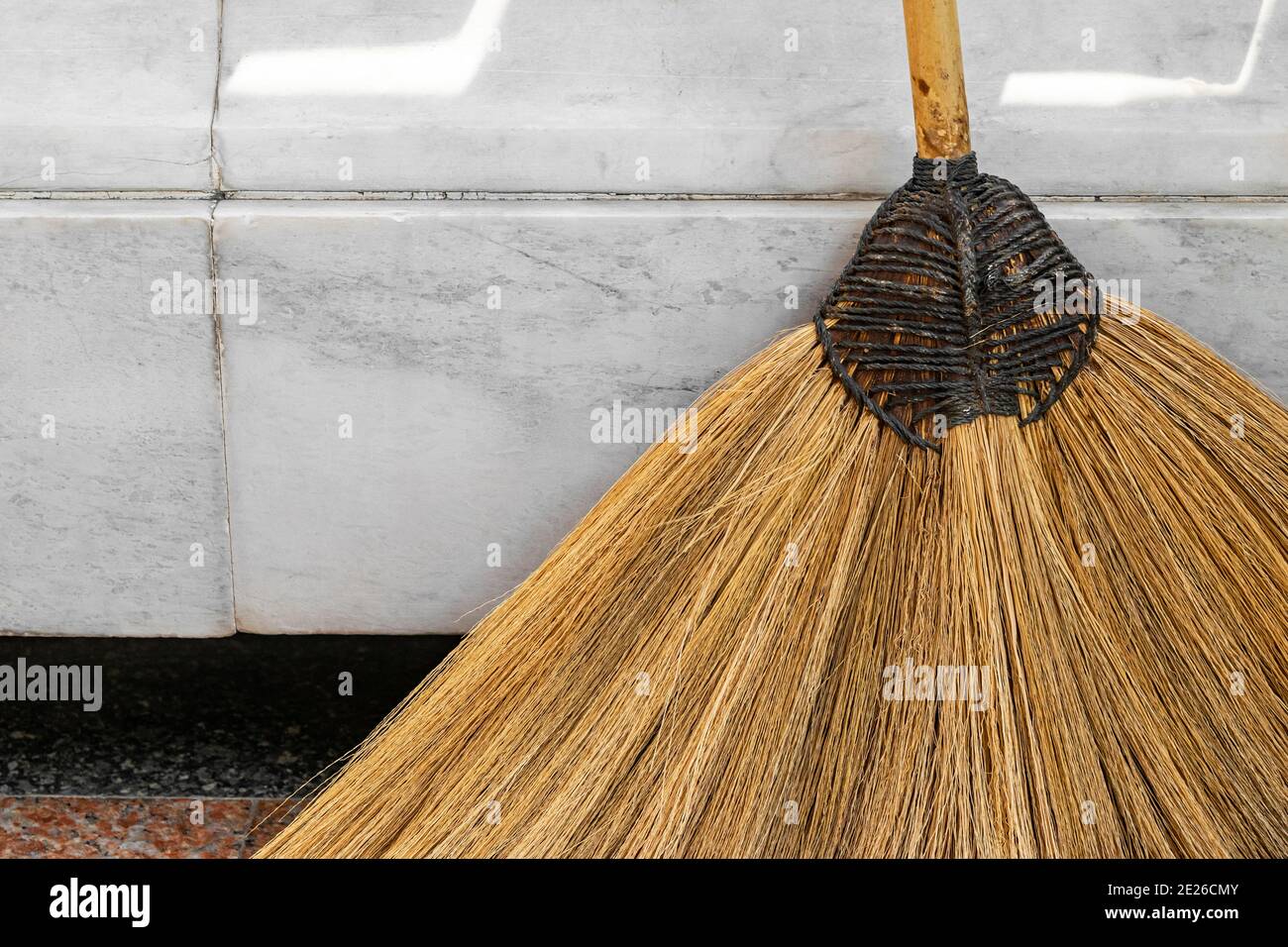 Sfondo astratto di scopa di paglia posto vicino a parete di marmo bianco con spazio per la copia Foto Stock