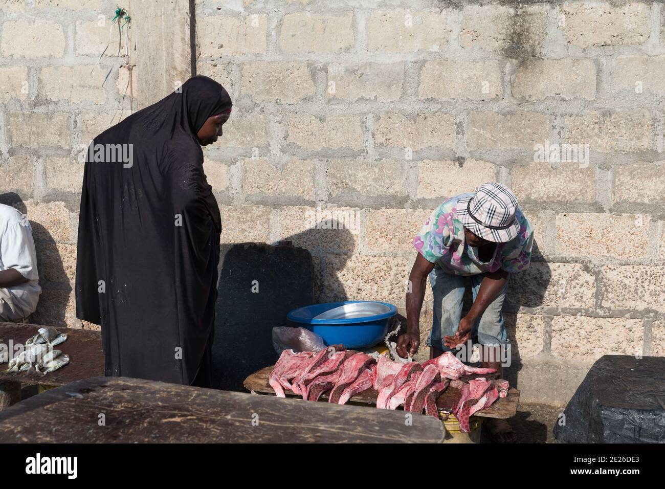 Donna che acquista pesce da un venditore. Foto Stock