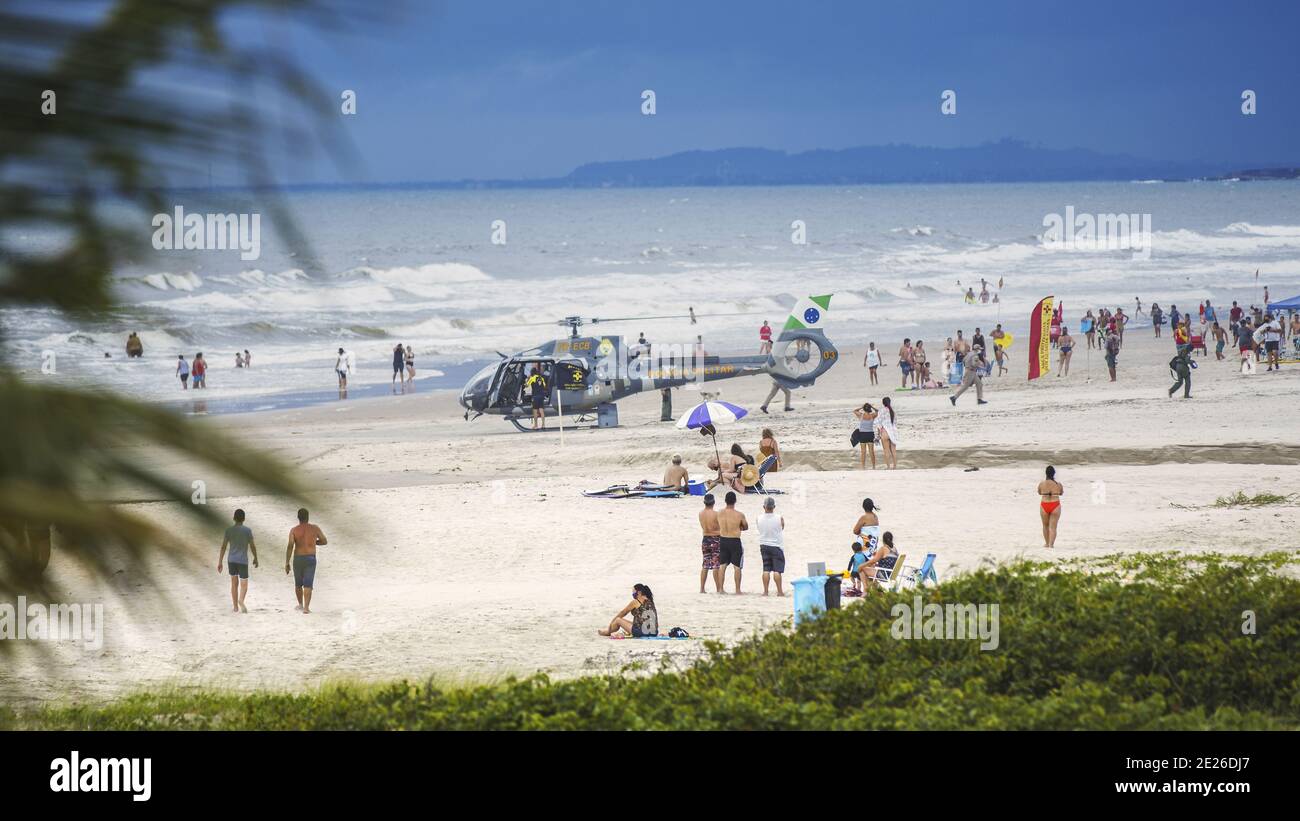 Guaratuba, Parana/Brasile - Dicembre 24 2020: Un elicottero di soccorso atterrato sulla spiaggia per un'assistenza di emergenza. I paramedici corrono sulla scena. Foto Stock