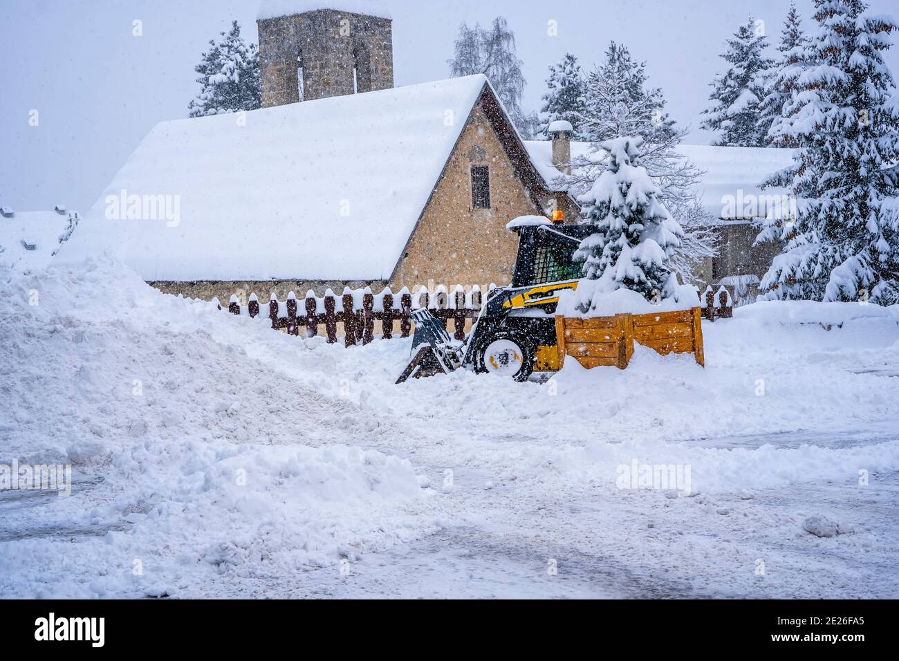 Auron, Francia - 01.01.2021: Pala gommata che rimuove la neve su una stazione sciistica. Eliminare la strada dalla neve. Foto di alta qualità Foto Stock