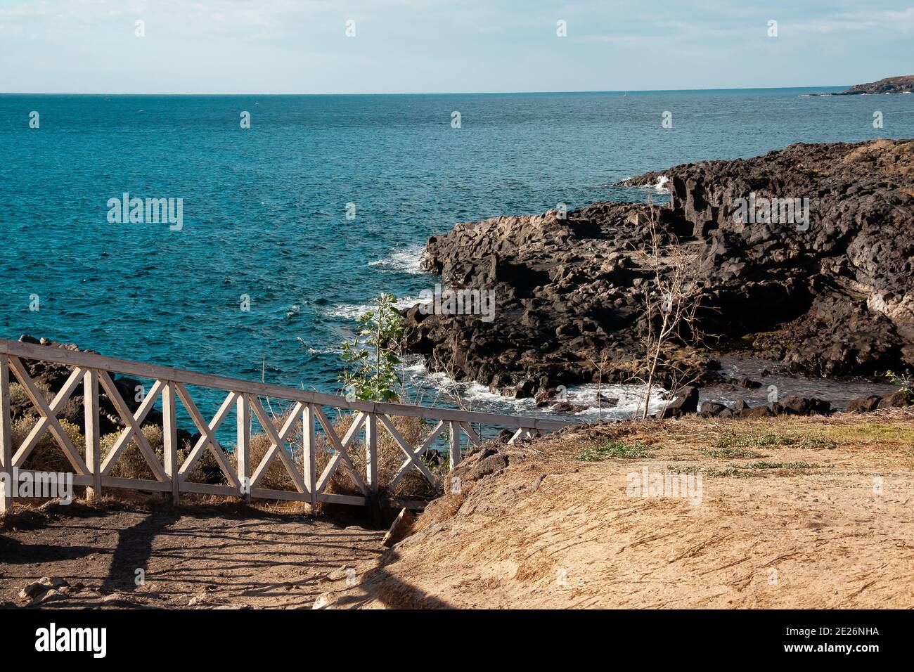 La fuga del thriller Sud Tenerife. Pietre vulcaniche nere e oceano Foto Stock