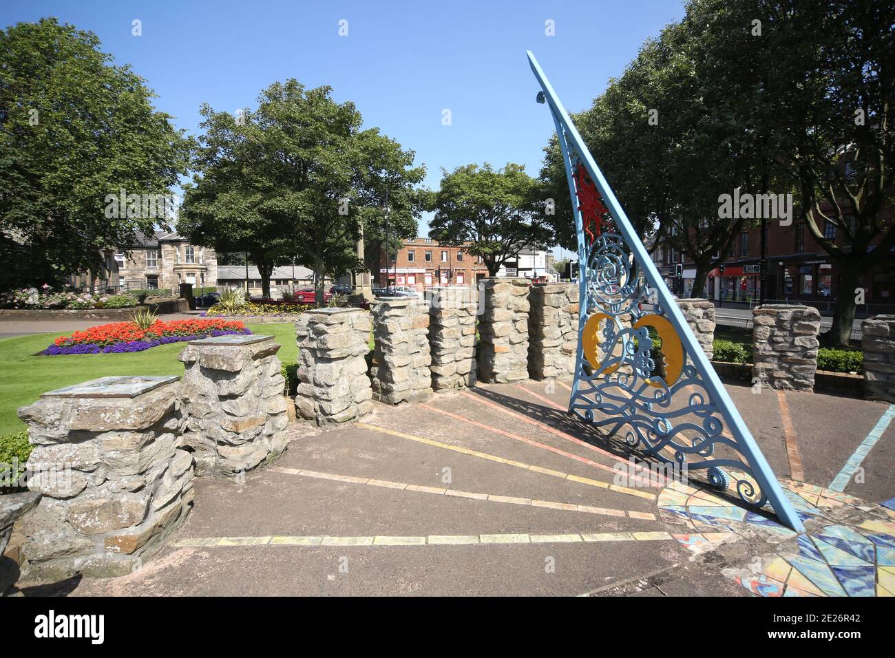 Prestwick Cross, Prestwick , Ayrshire, Scozia. REGNO UNITO. L'insolita meridiana mostra dalle 4:00 alle 20:00 in orario. I segnaora sono su colonne costruite in pietra con motivi che denotano gli interessi locali. Grande gnomone trafitto con elaborati simboli di sole, luna, stelle e zodiaco. La piastra è di concre &tegole, facendo una mappa approssimativa del Firth di Clyde, con l'Isola di Arran, e alcune strade sulla terraferma. La meridiana è stata concepita e progettata da studenti d'Arte della Prestwick Academy con l'assistenza di membri del Dipartimento d'Arte, che hanno lavorato in collaborazione con l'artista Elspeh Bennie di Balfron. Foto Stock