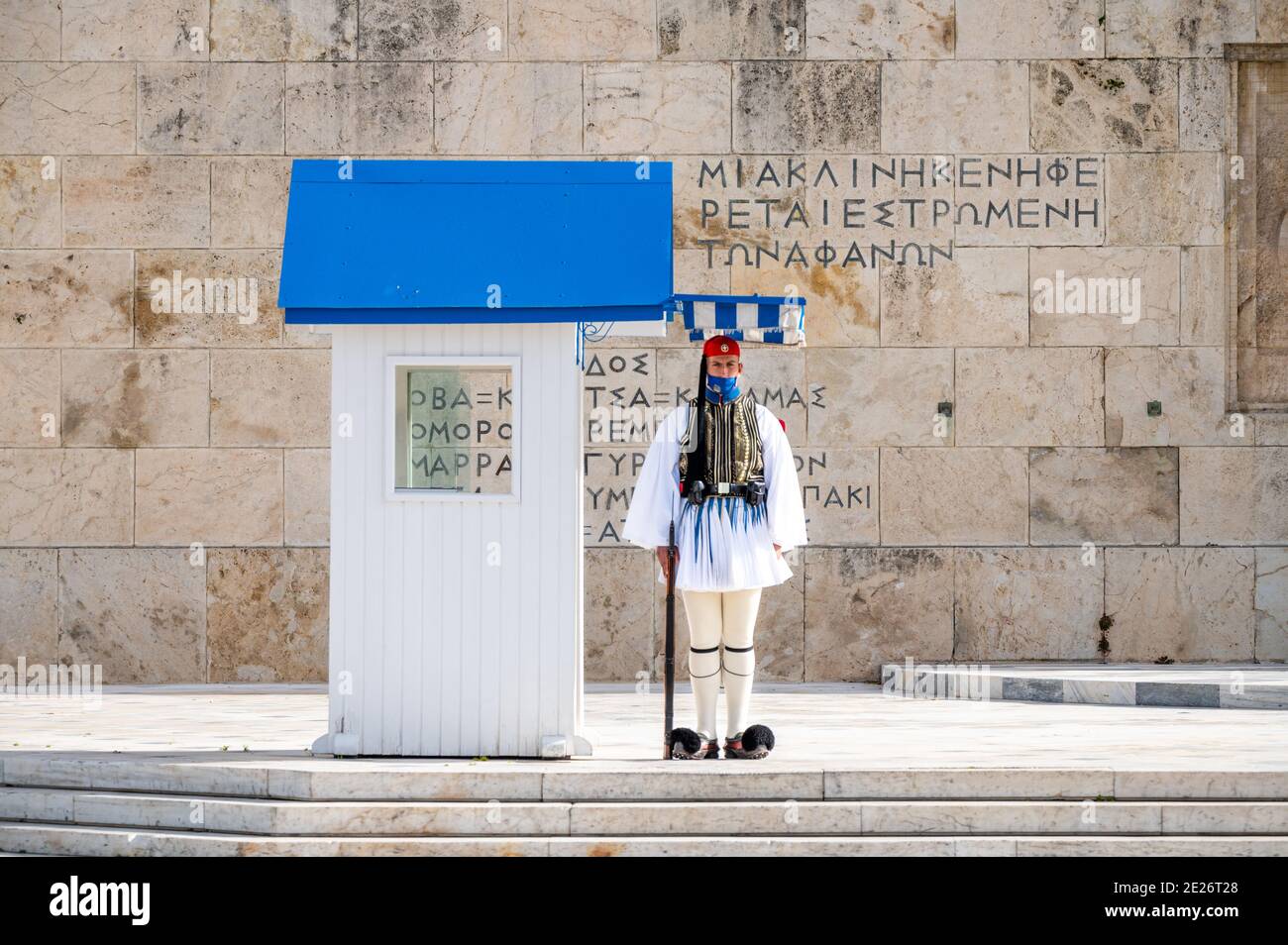 Soldato della guardia presidenziale greca (Evzone) con maschera davanti alla tomba del soldato sconosciuto ad Atene, Grecia Foto Stock