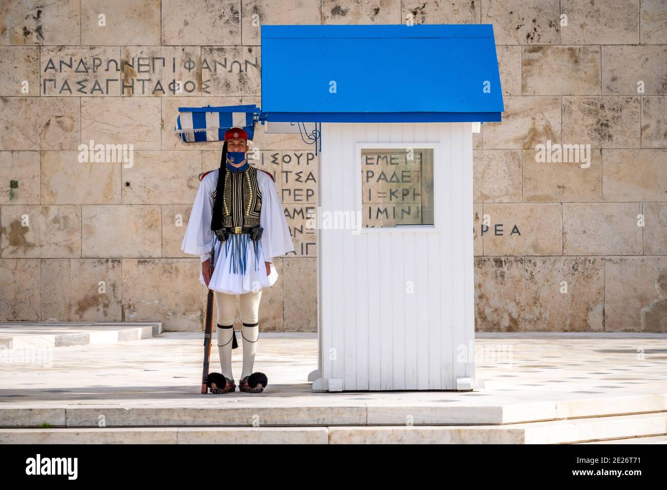 Soldato della guardia presidenziale greca (Evzone) con maschera davanti alla tomba del soldato sconosciuto ad Atene, Grecia Foto Stock