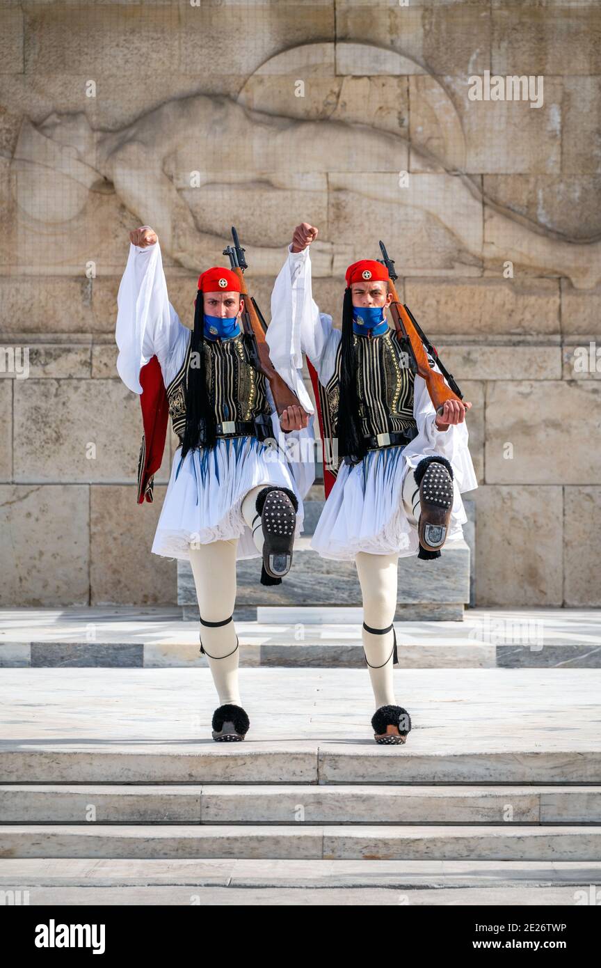 Soldati della guardia presidenziale greca (Evzone) con maschera davanti alla tomba del soldato sconosciuto ad Atene, Grecia Foto Stock