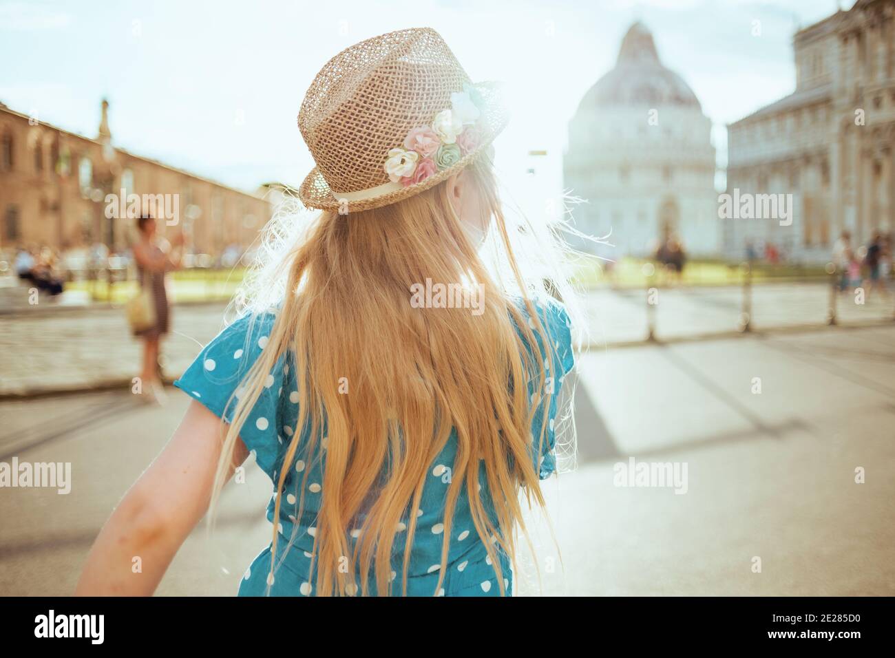Visto da dietro la ragazza trendy in generale blu e cappello esplorando le  attrazioni vicino alla Cattedrale di Pisa Foto stock - Alamy