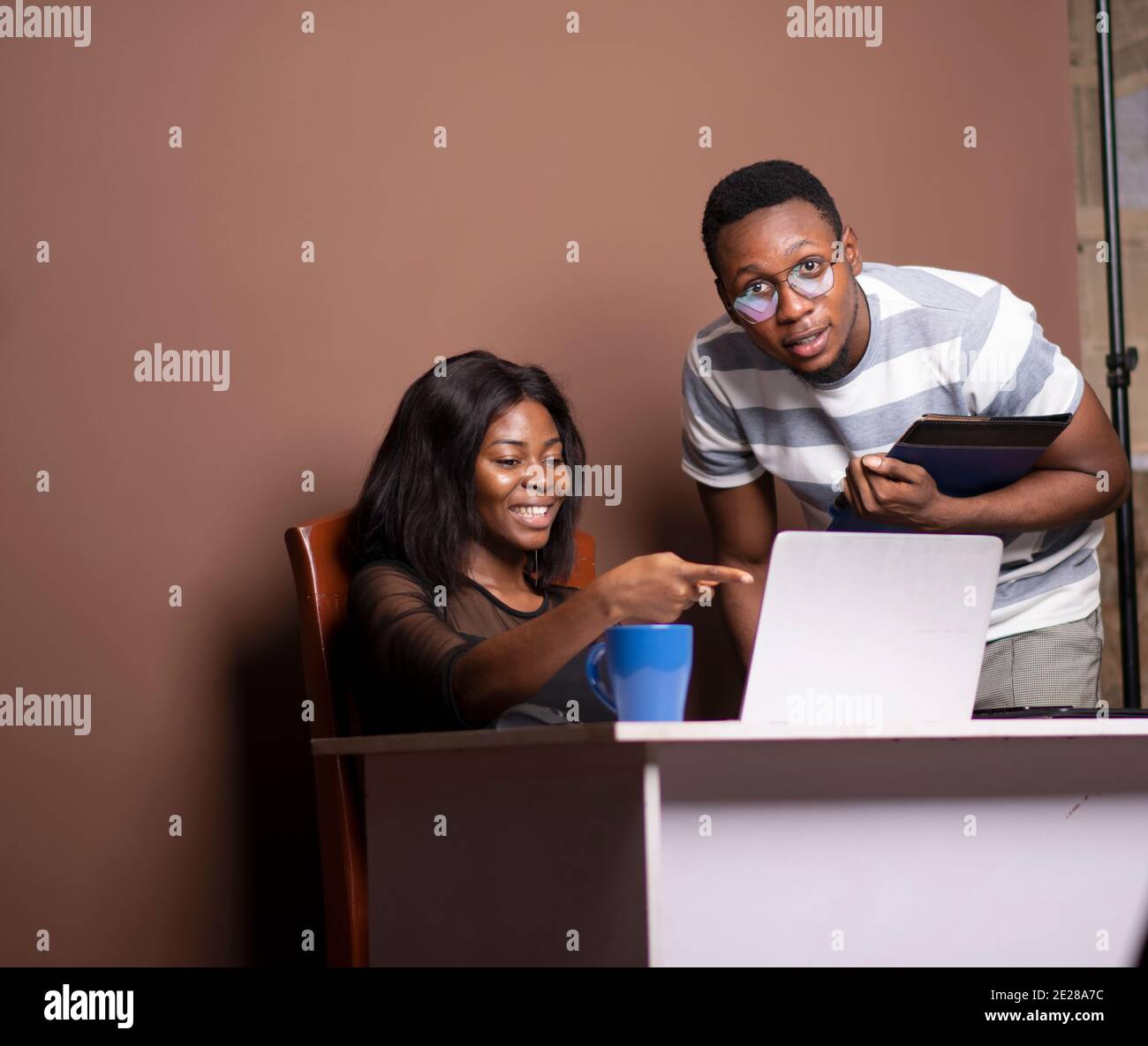 una donna e un giovane uomo che guarda un computer portatile Foto Stock