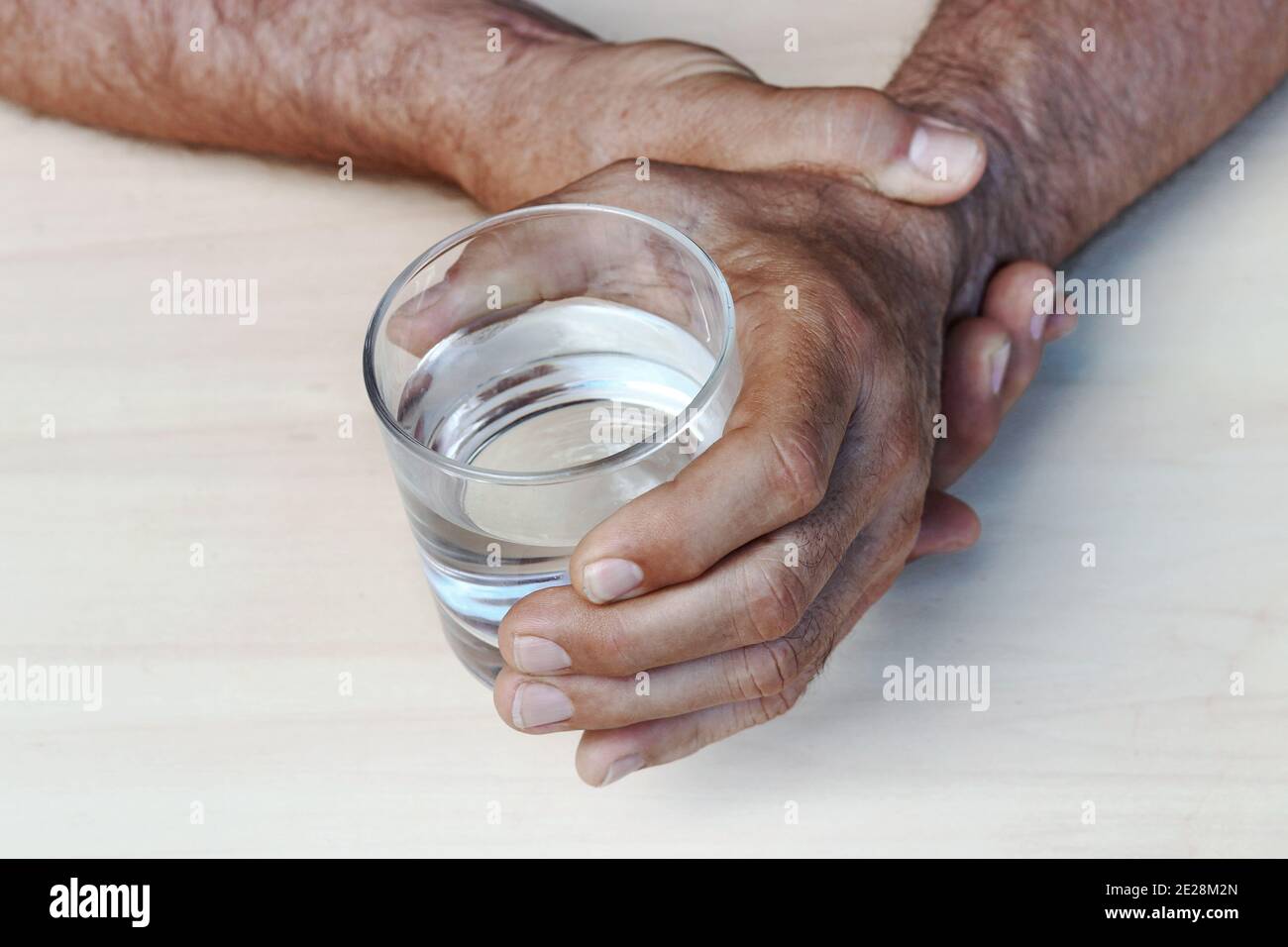 Le mani di un uomo con malattia di Parkinson tremano. Mani tremanti di un uomo anziano Foto Stock