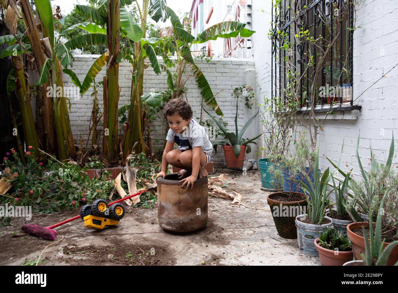Thiago gioca da solo nel cortile di fronte durante il suo confinamento a causa della pandemia COVID-19 nella sua casa a Città del Messico, Messico il 7 luglio 2020. Foto Foto Stock