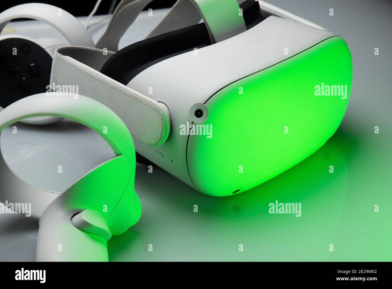 Visore VR bianco di nuova generazione isolato su sfondo bianco con luci futuristiche scintillanti. Cuffia per realtà virtuale Oculus quest 2 Foto Stock