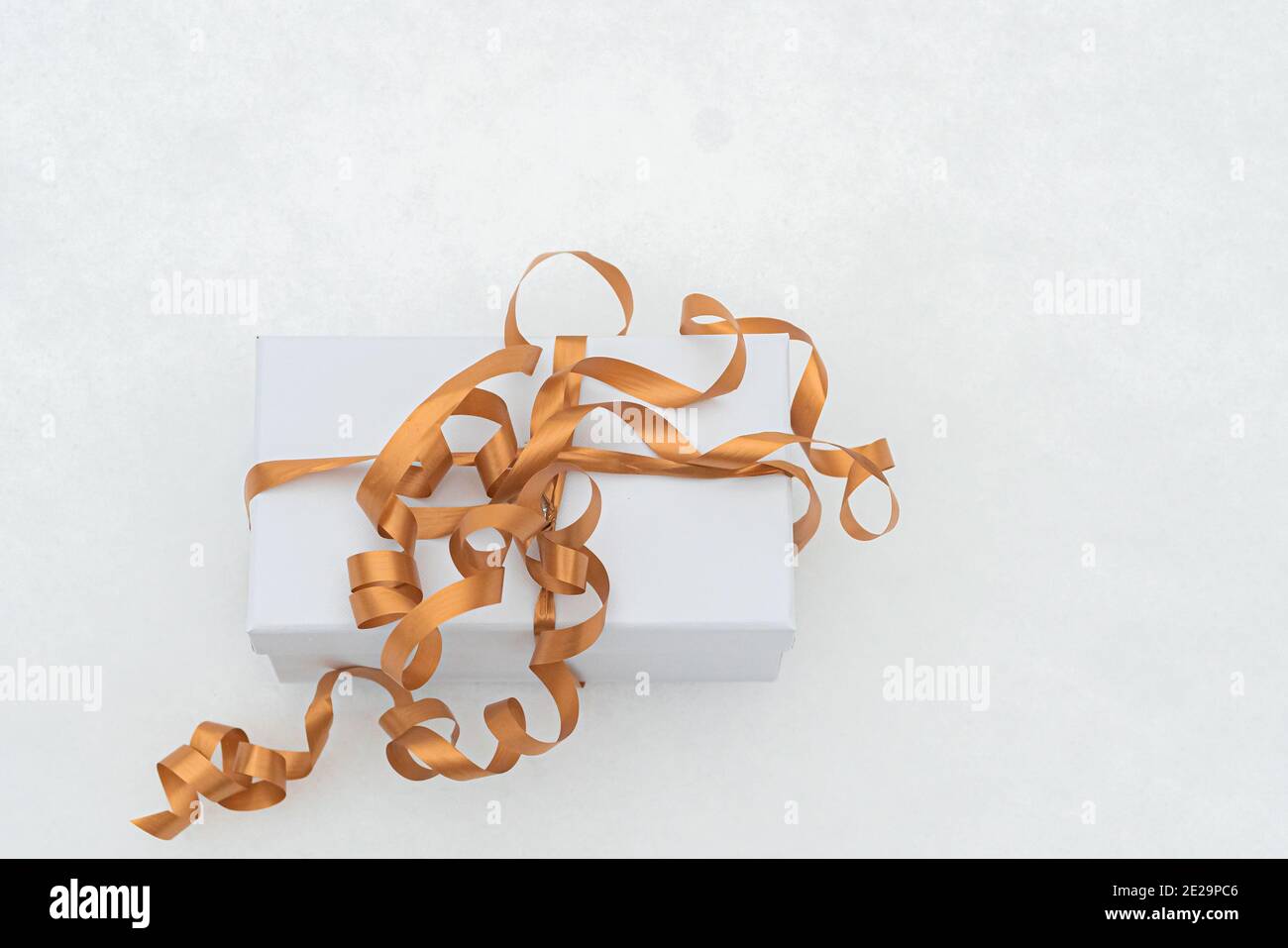 Scatola bianca con nastro dorato sulla neve. Concetto di congratulazioni per San Valentino,. Foto di alta qualità Foto Stock