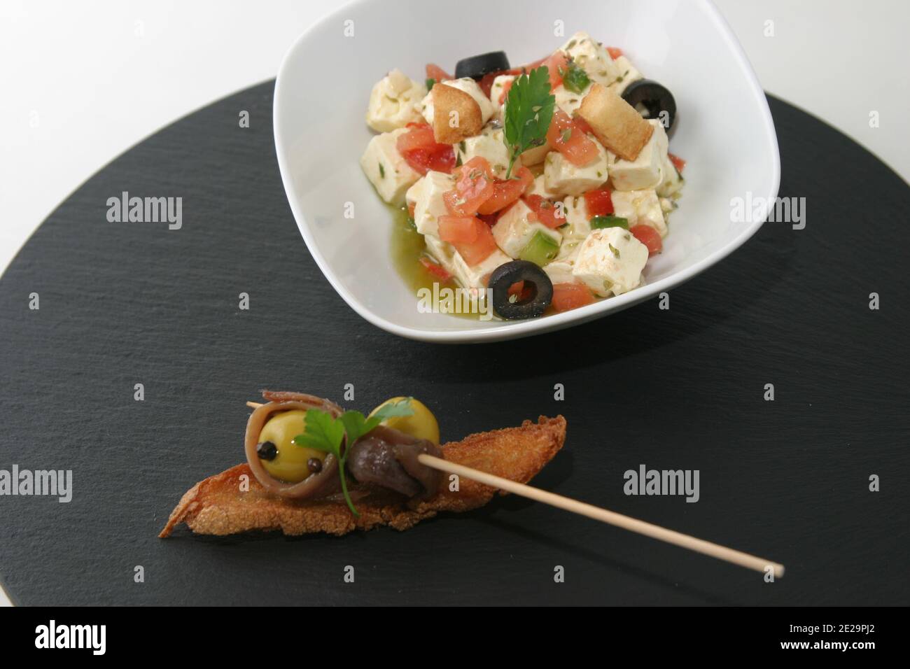 Insalata di tofu e brindate con acciughe, olive e caviale nero. Foto Stock