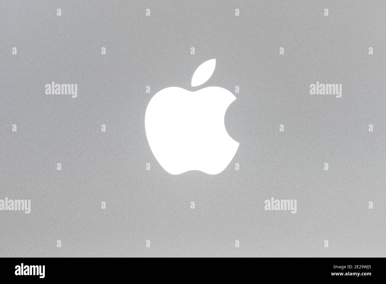 Macro shot del logo Apple retroilluminato MacBook Pro, struttura in alluminio spazzolato. Foto Stock