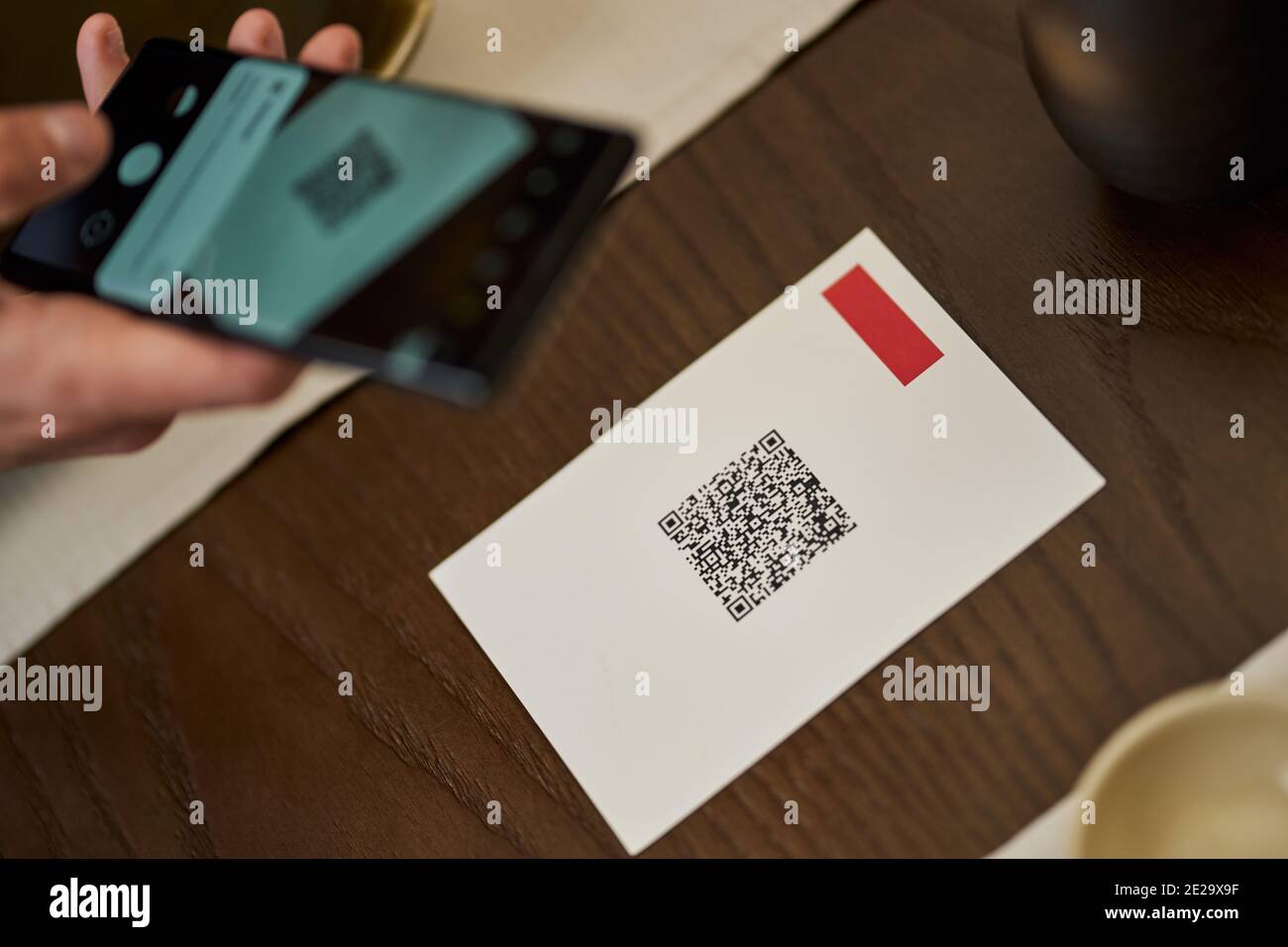 Foto ritagliata di una persona che esegue la scansione di un codice QR del menu del ristorante con l'aiuto dello smartphone Foto Stock