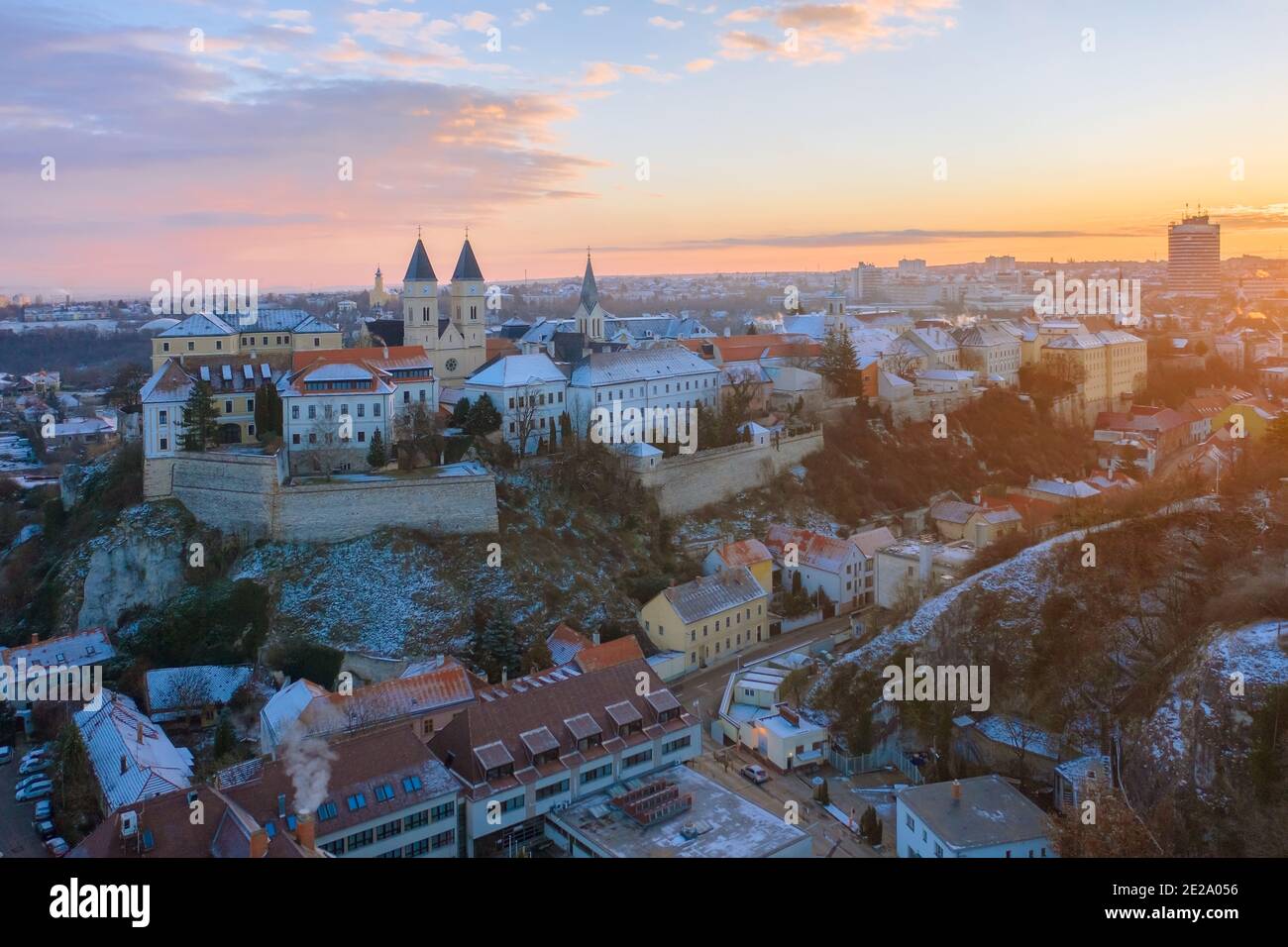 Veszprém, Ungheria - incredibile vista panoramica aerea innevata del centro di Veszprém e del quartiere del castello in una mattinata invernale con splendida alba dorata. Foto Stock