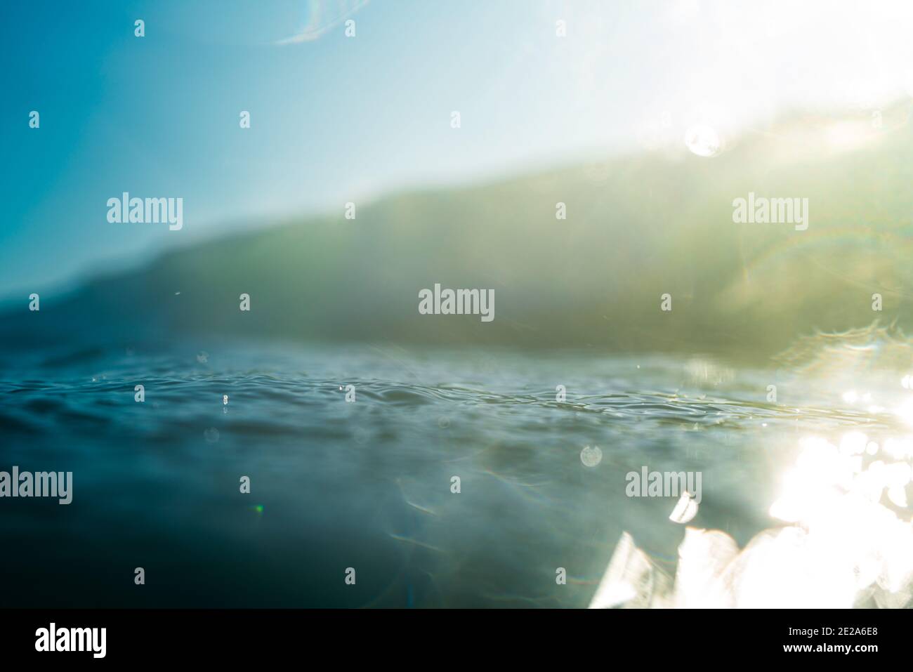 Onde di rottura e spray, acqua bianca e luce che si riflette sulla superficie dell'acqua in movimento Foto Stock