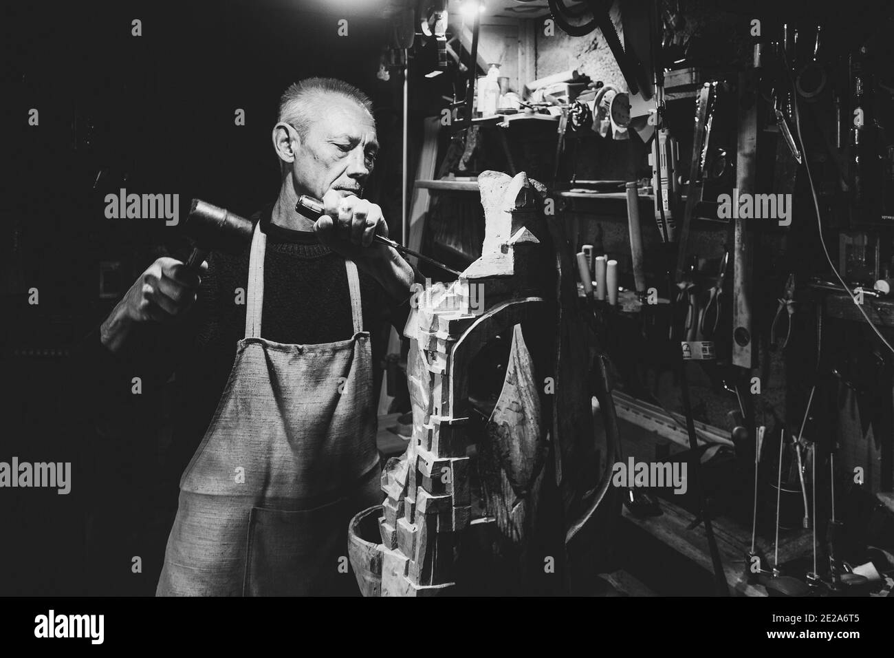 Maestro di legname 50 - 55 anni crea la scultura in legno in officina, la fotografia in bianco e nero Foto Stock Maestro di legname 50 - 55 anni crea la scultura in legno in officina, la fotografia in bianco e nero Foto Stock