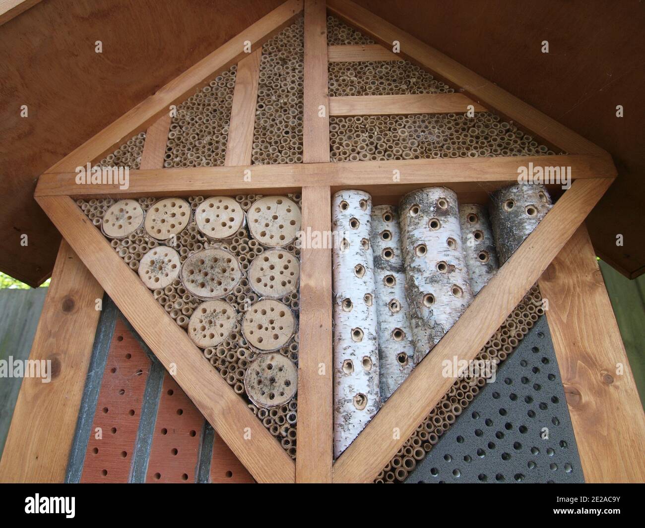 Un hotel di bug fatto di legno e prodotti naturali in un parco. Foto Stock