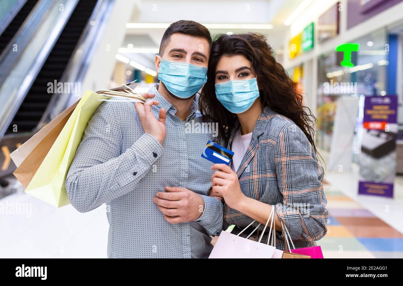 Coppia innamorata con carta di credito e borse per la spesa Foto Stock