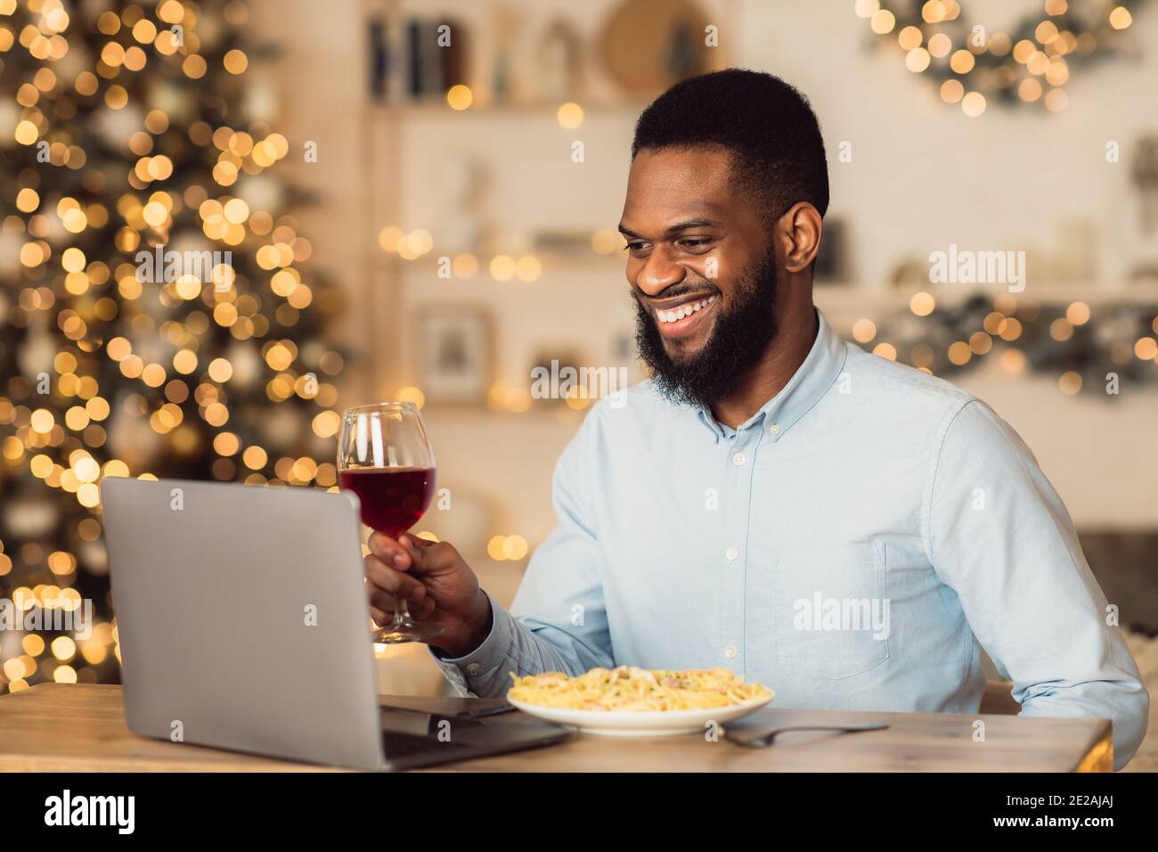 Black man cena bevendo vino facendo videocall Foto Stock