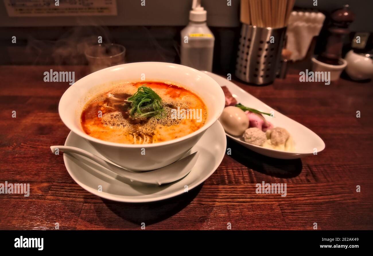 Toshima, Tokyo, Giappone - Settembre 26 2020: Una ciotola di spiccati tagliatelle di tantanmen e alcuni lati sul banco di Nakiryu, un noodle vincitore della stella Michelin Foto Stock