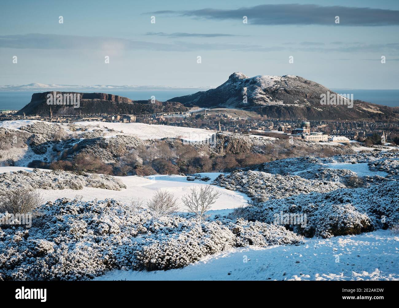 Arthurs Seat e Salisbury Crags Edimburgo in inverno neve on una giornata di sole Foto Stock