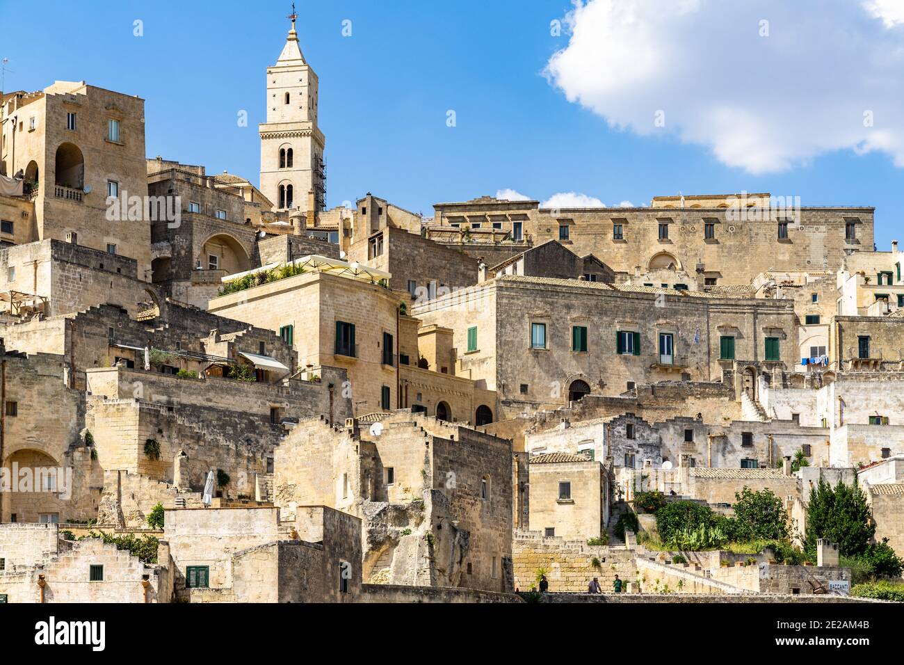 Tipici edifici e case del quartiere di Sasso Caveoso a Matera, con il campanile della cattedrale di Matera in cima, Basilicata, Italia Foto Stock