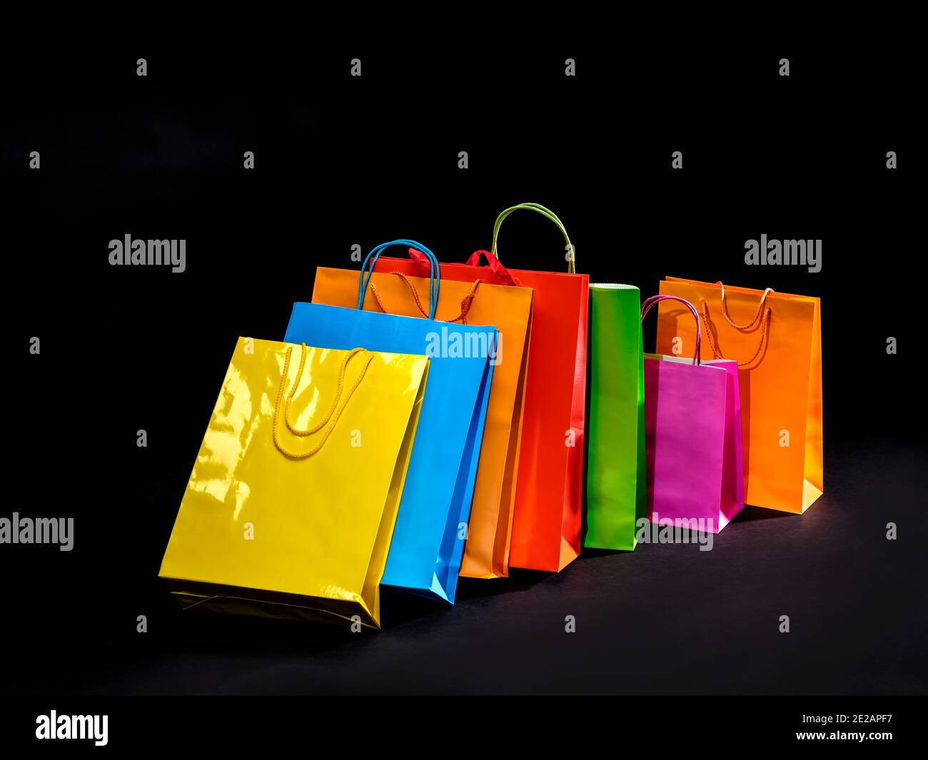 Sacchetti di carta colorati per lo shopping e i regali. Concetto di vendita online. Merci in vendita. Sfondo nero. Foto Stock
