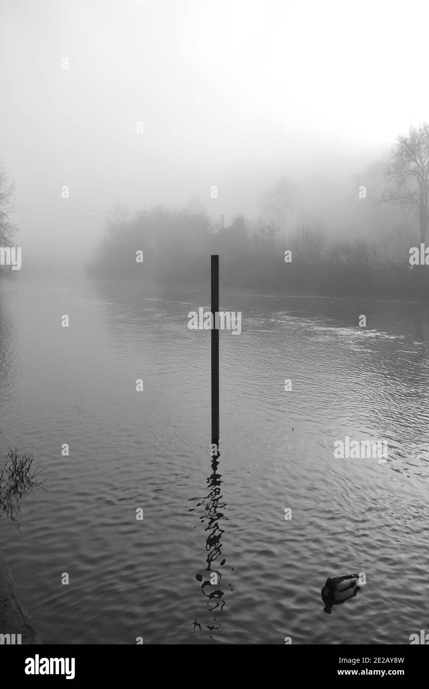 Indicatore del livello dell'acqua nel fiume severn, Ironbridge, Shropshire in una giornata di nebbia. Misurazione dei livelli d'acqua durante la stagione delle alluvioni in inverno su una nebbia Foto Stock