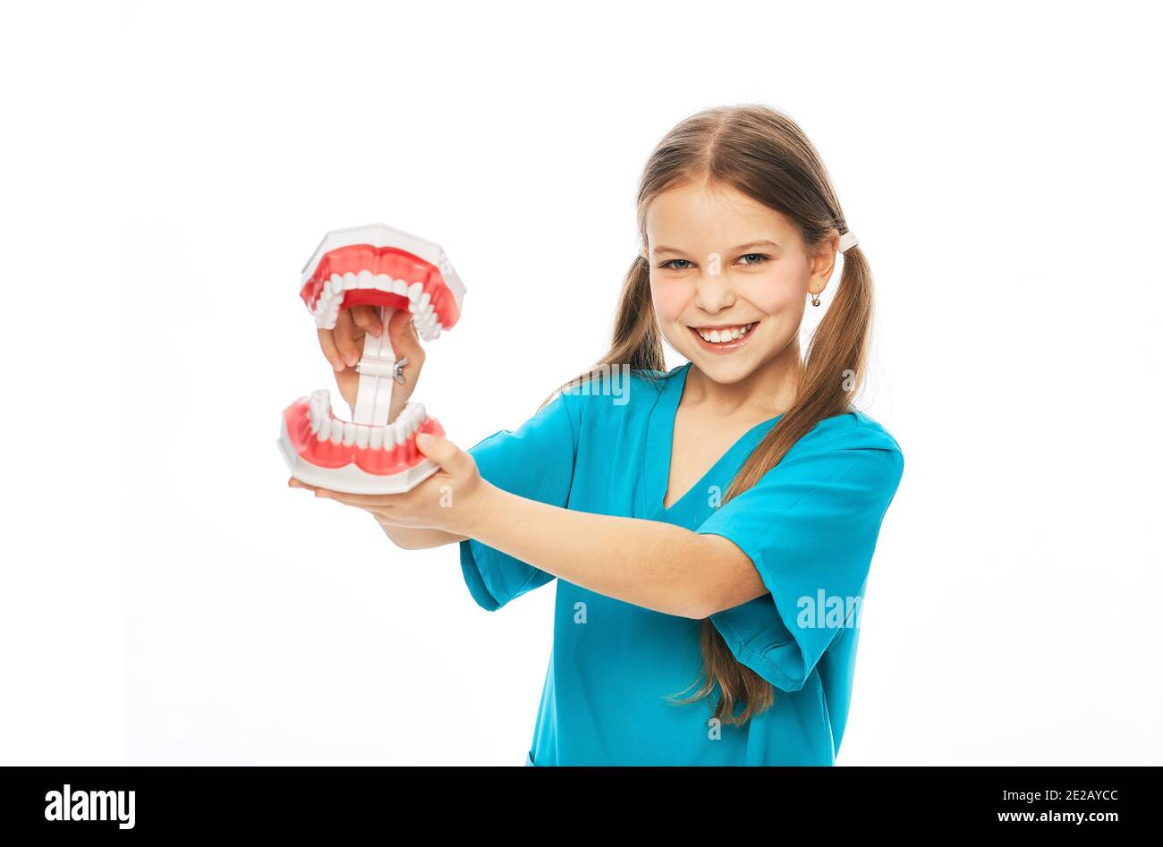 Concetto di salute dentale per bambini. Ragazza carina che mostra un modello anatomico di denti, su uno sfondo bianco Foto Stock