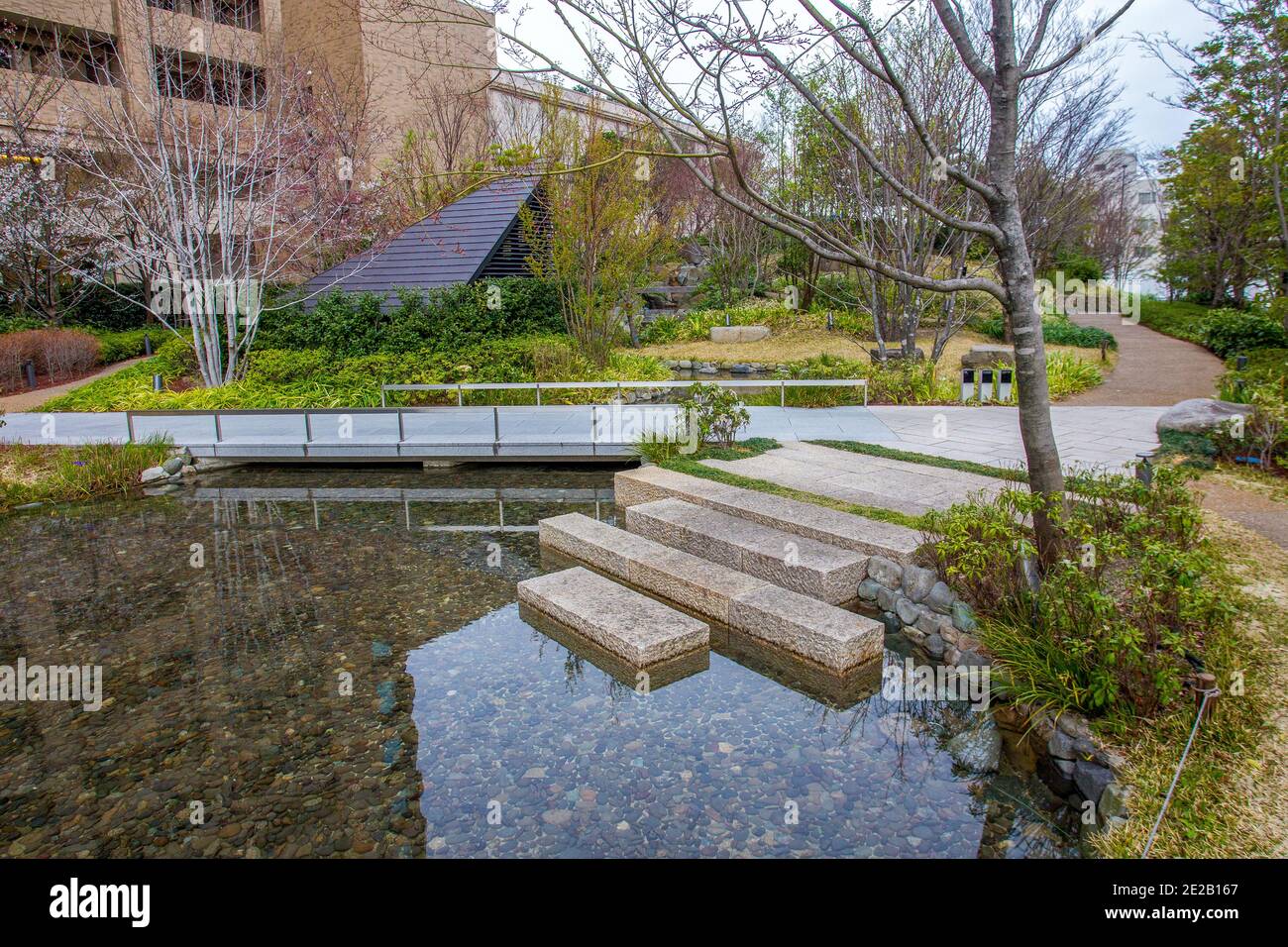 Parco vicino ad alcuni hotel nel centro di Osakain. Piccola isola in stagno . Arriva la primavera! Foto Stock