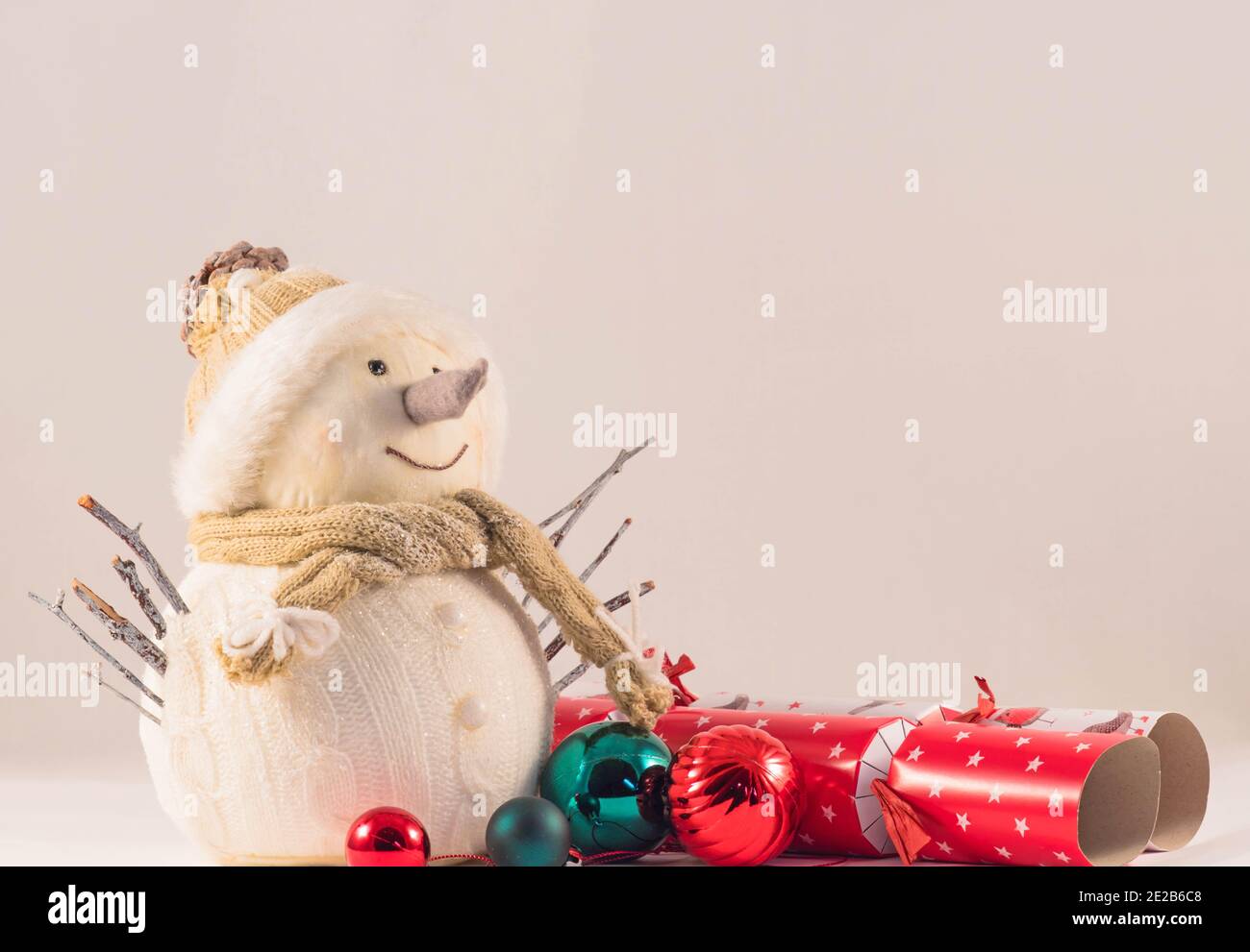 Decorazione di Snowman che indossa cappello e sciarpa con baubles e cracker intorno. Gennaio 2021. Foto Stock