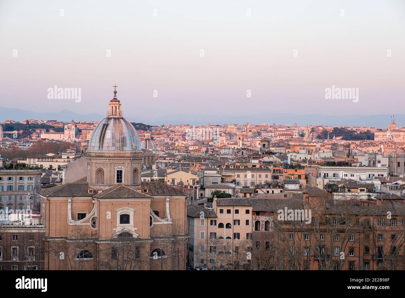 Vista sul centro di Roma, Italia, da Trastevere attraverso il fiume Tevere, al tramonto. Chiesa di San Giovanni Battista dei Fiorentini in primo piano. Foto Stock
