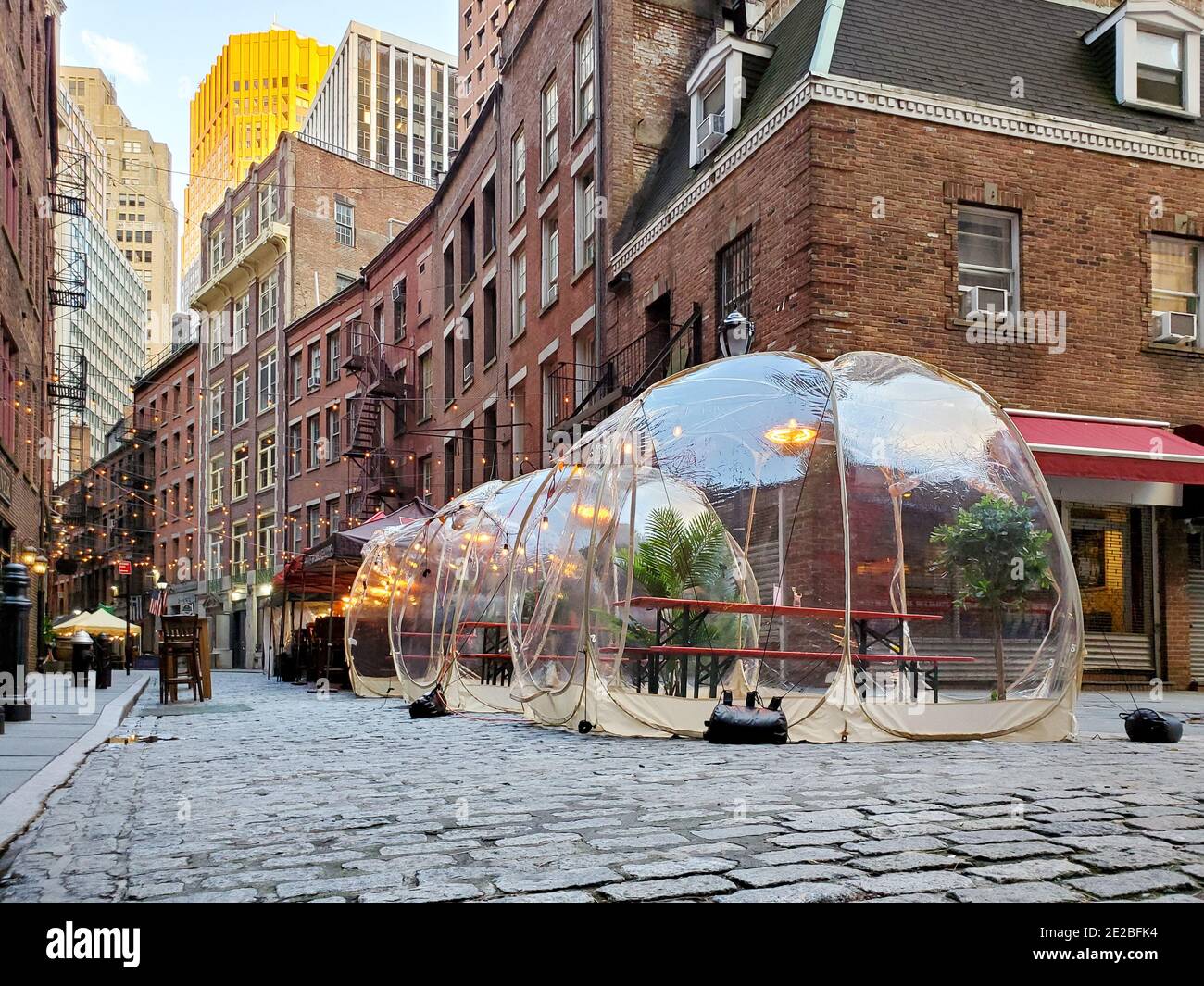 Tavoli da pranzo all'aperto in Bubbles lungo Stone Street durante la pandemia del coronavirus nel centro di Manhattan, New York City New York Foto Stock