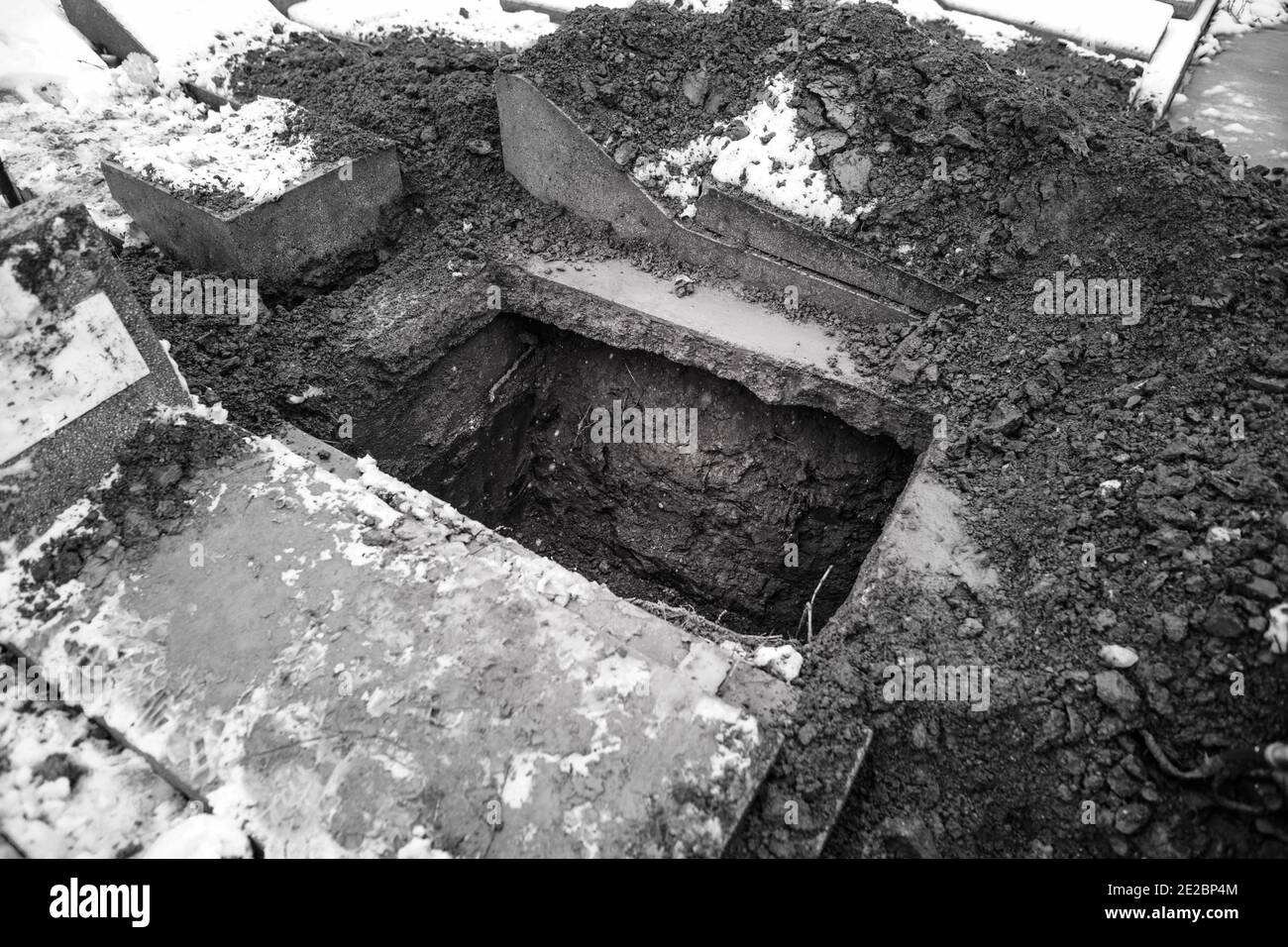 Tomba vuota in un cimitero durante una giornata invernale fredda e nevosa. Foto Stock