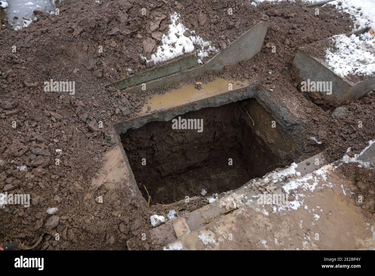 Tomba vuota in un cimitero durante una giornata invernale fredda e nevosa. Foto Stock