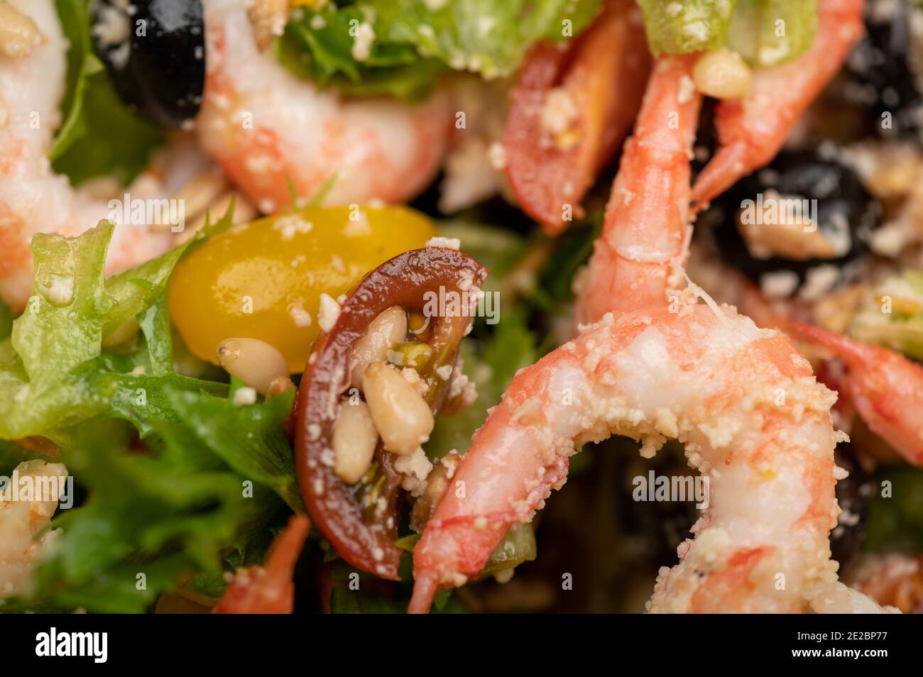 Insalata di verdure con gamberi e pinoli su un piatto. Cibo fatto in casa. Primo piano Foto Stock