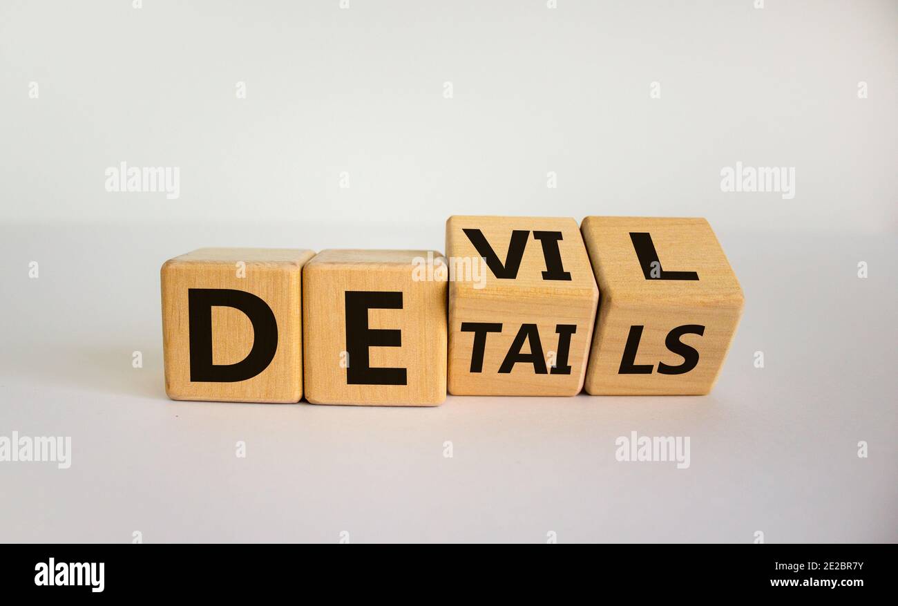 Diavolo nel simbolo dei dettagli. Girò i cubetti e cambiò la parola 'dettagli' in 'male'. Splendido sfondo bianco. Affari e diavolo nei dettagli con Foto Stock