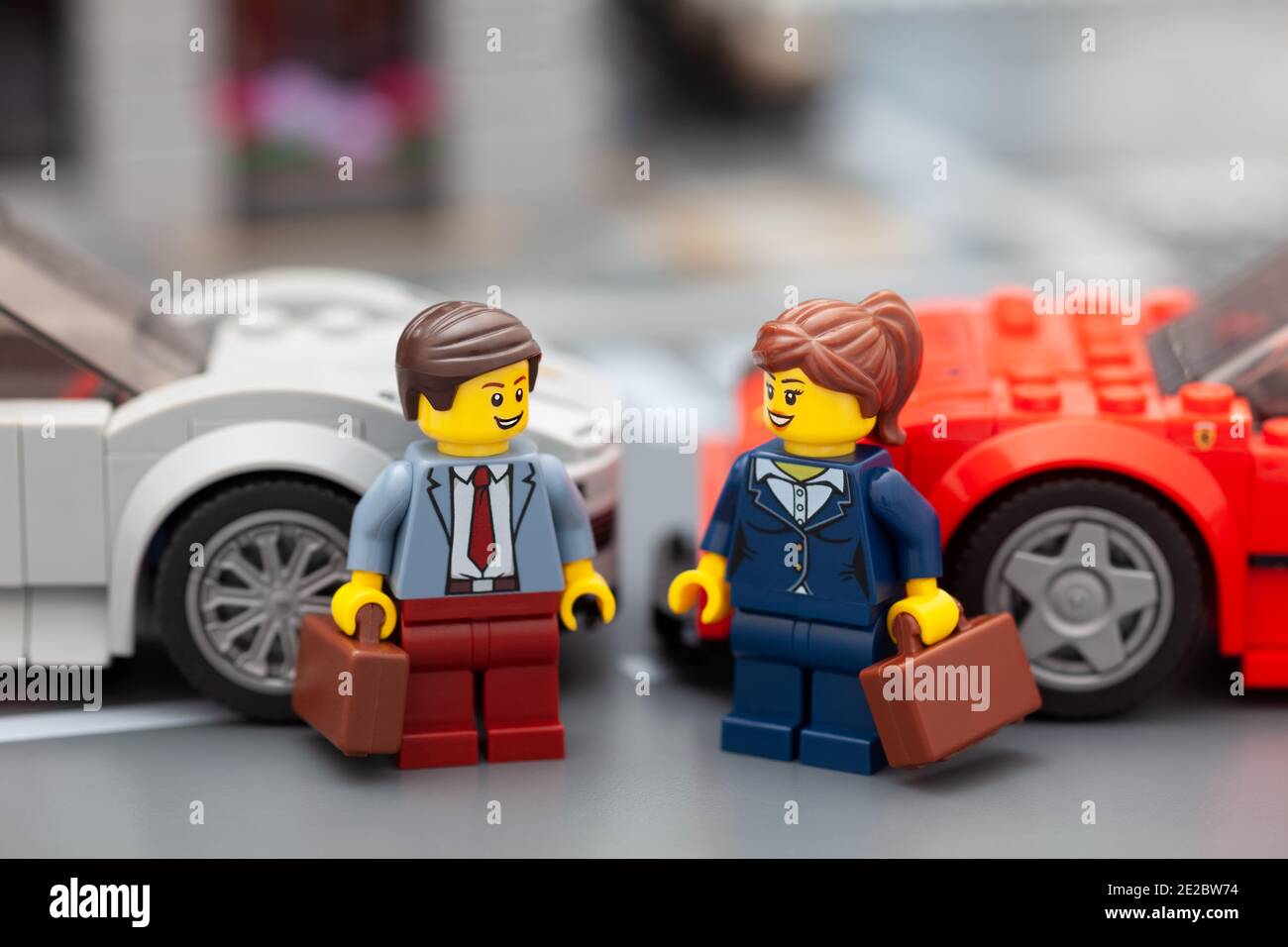 Tambov, Federazione Russa - 08 gennaio 2021 Minifisie uomo d'affari e donna d'affari Lego in piedi vicino alle loro auto sportive. Foto Stock
