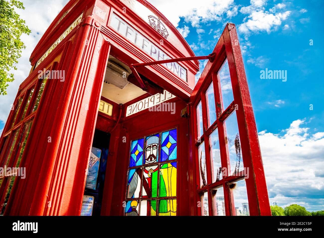 Iconica scatola telefonica rossa modificata con decorazioni in vetro colorato sul Victoria Embankment, Londra, Regno Unito Foto Stock