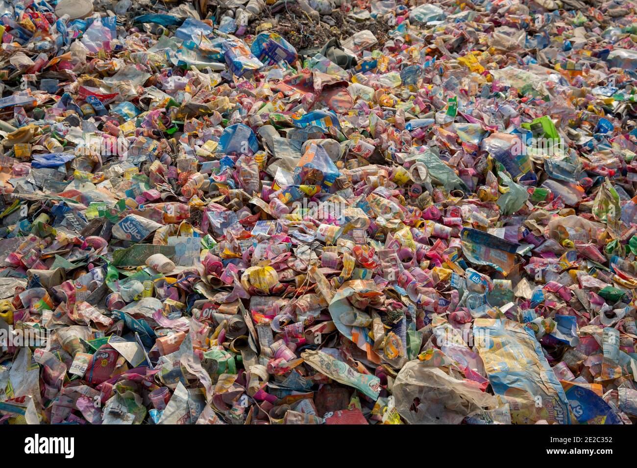 Diverse etichette di bottiglie per animali da compagnia scaricate accanto a un centro di riciclaggio di plastica a Brahmanbaria, Bangladesh. Foto Stock