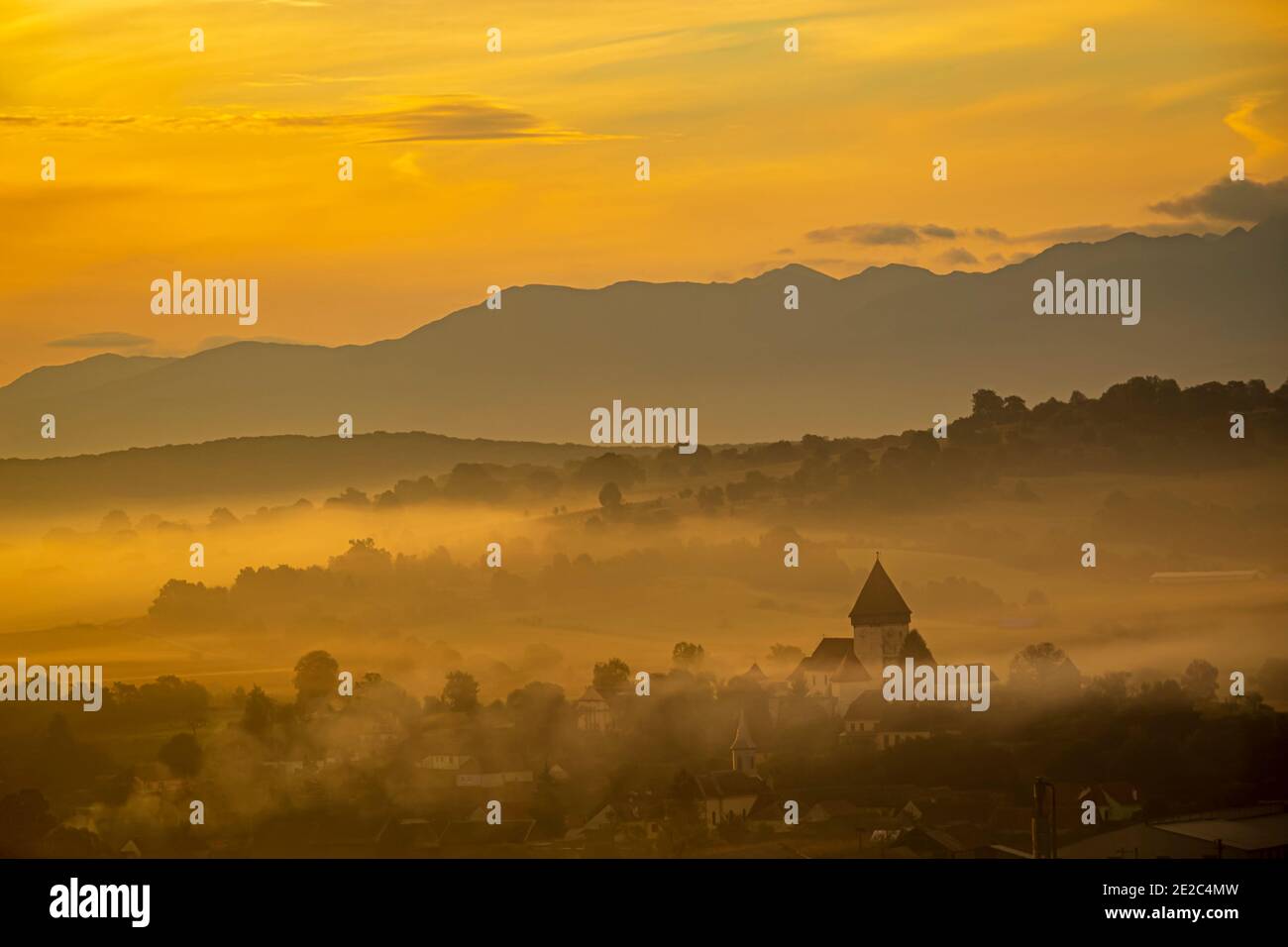 La chiesa fortificata di Hosman all'alba sotto uno spesso strato di nebbia e fumo. Foto scattata il 3 ottobre 2020 presso Hosman, regione della Transilvania, R. Foto Stock