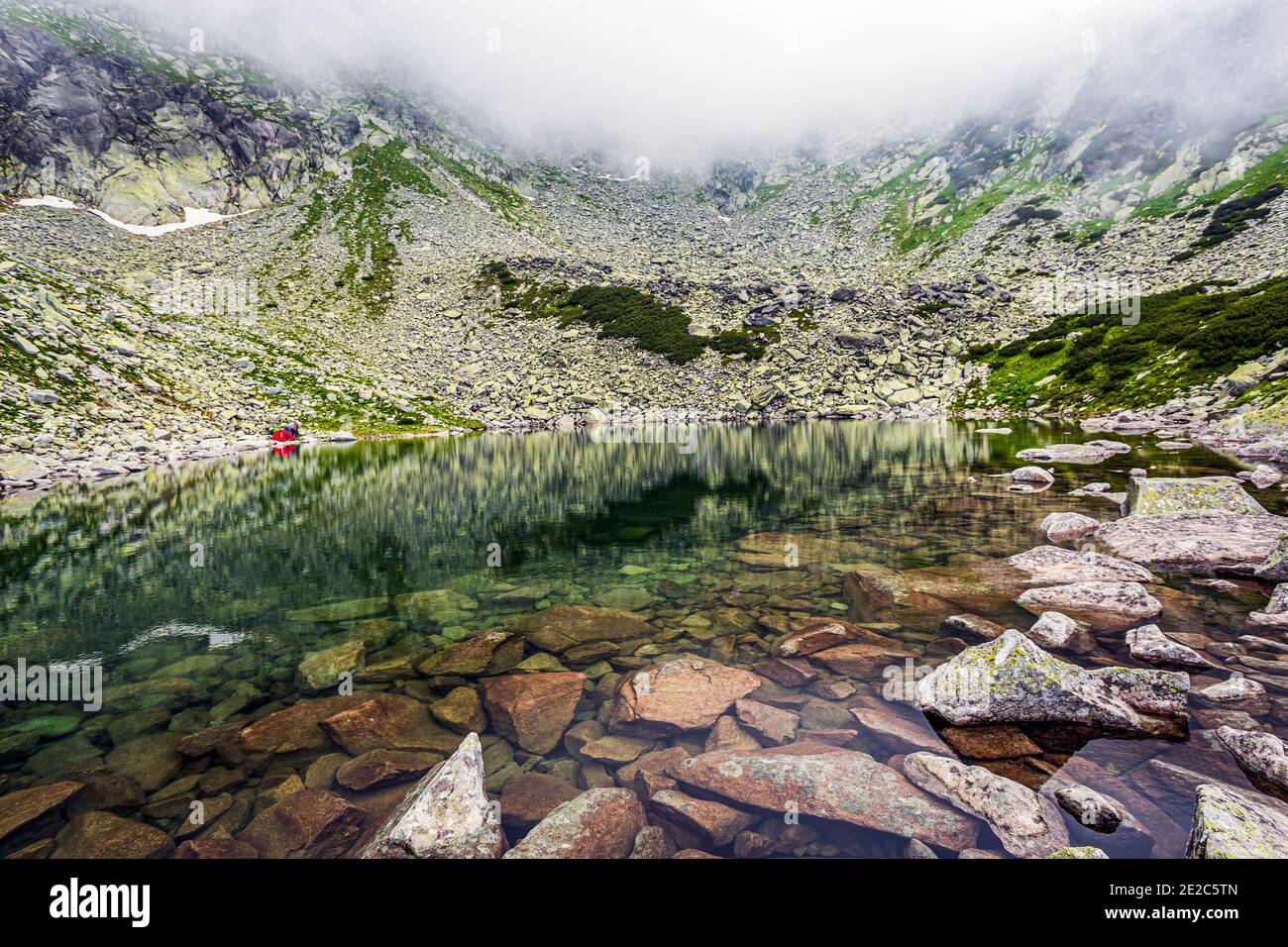 Il bellissimo lago glaciale di Stevia in una nebbiosa giornata estiva nei Monti Retezat. Foto scattata il 12 luglio 2020 durante un'escursione nella Ret Carfata Foto Stock