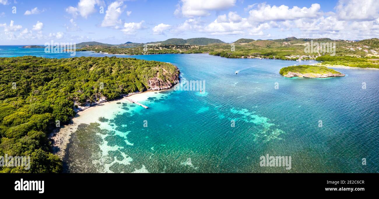 Spiaggia Paradiso e baia nell'arcipelago dei Caraibi nelle Antille con acque turchesi trasparenti e barriere coralline. Panorama del drone aereo di costa bianca Foto Stock
